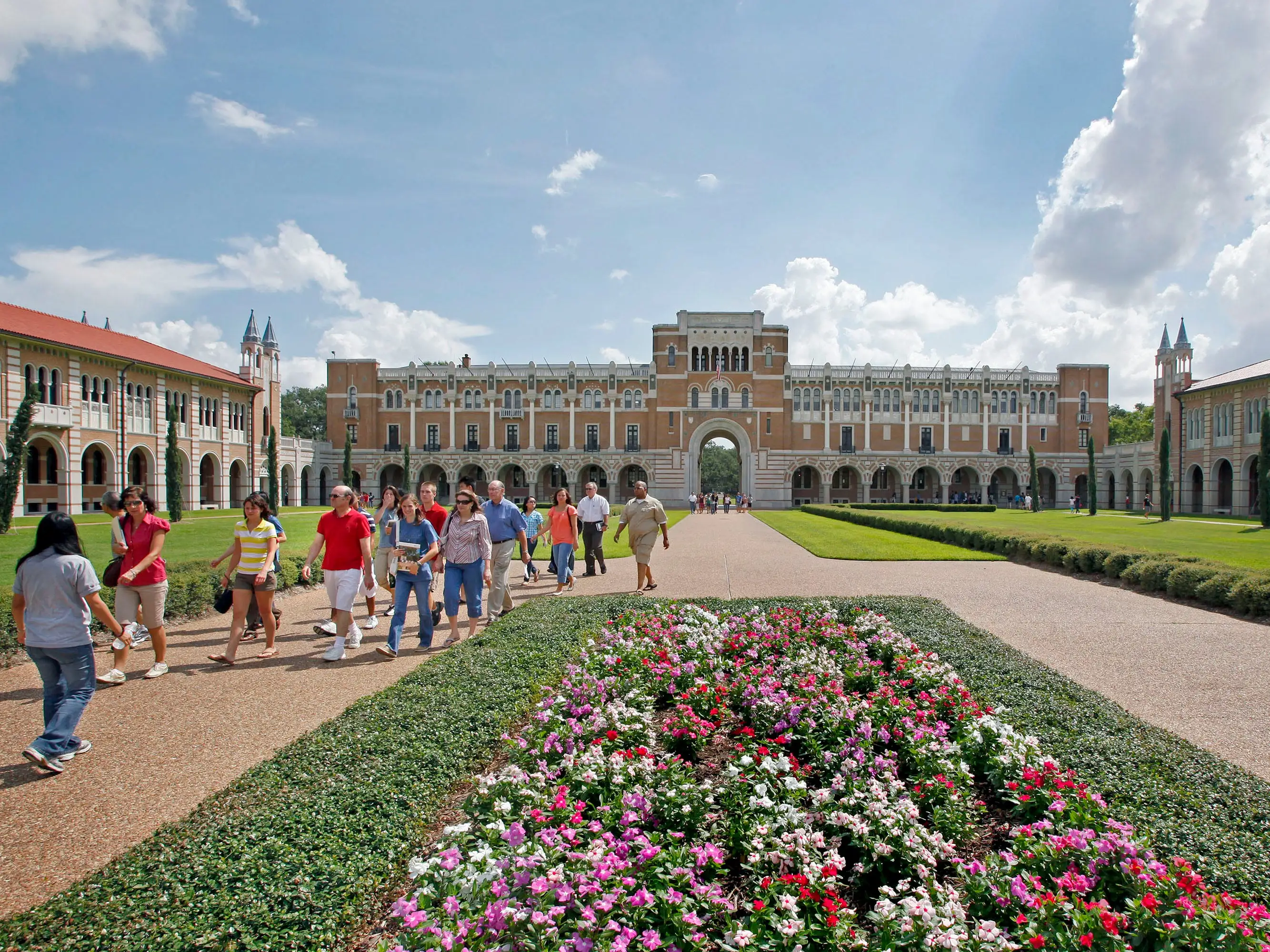 Students walk in the gardens of a college campus.