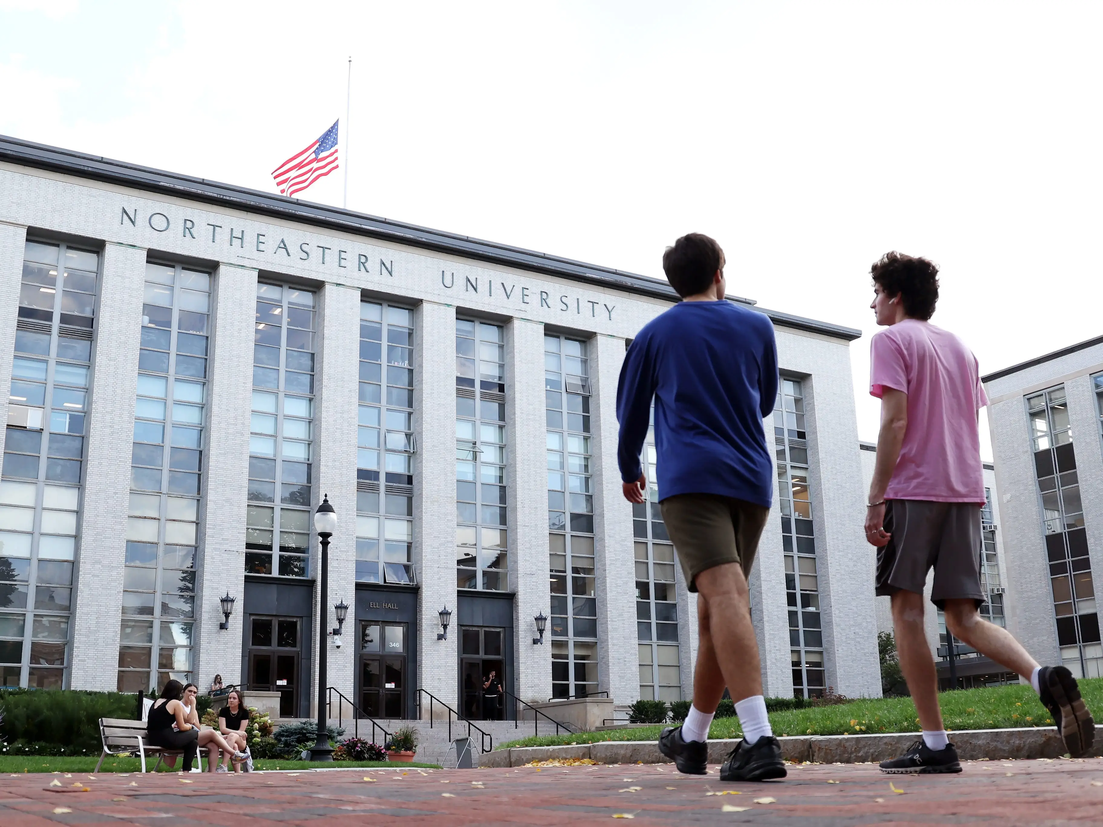 Two students walk on a college campus.