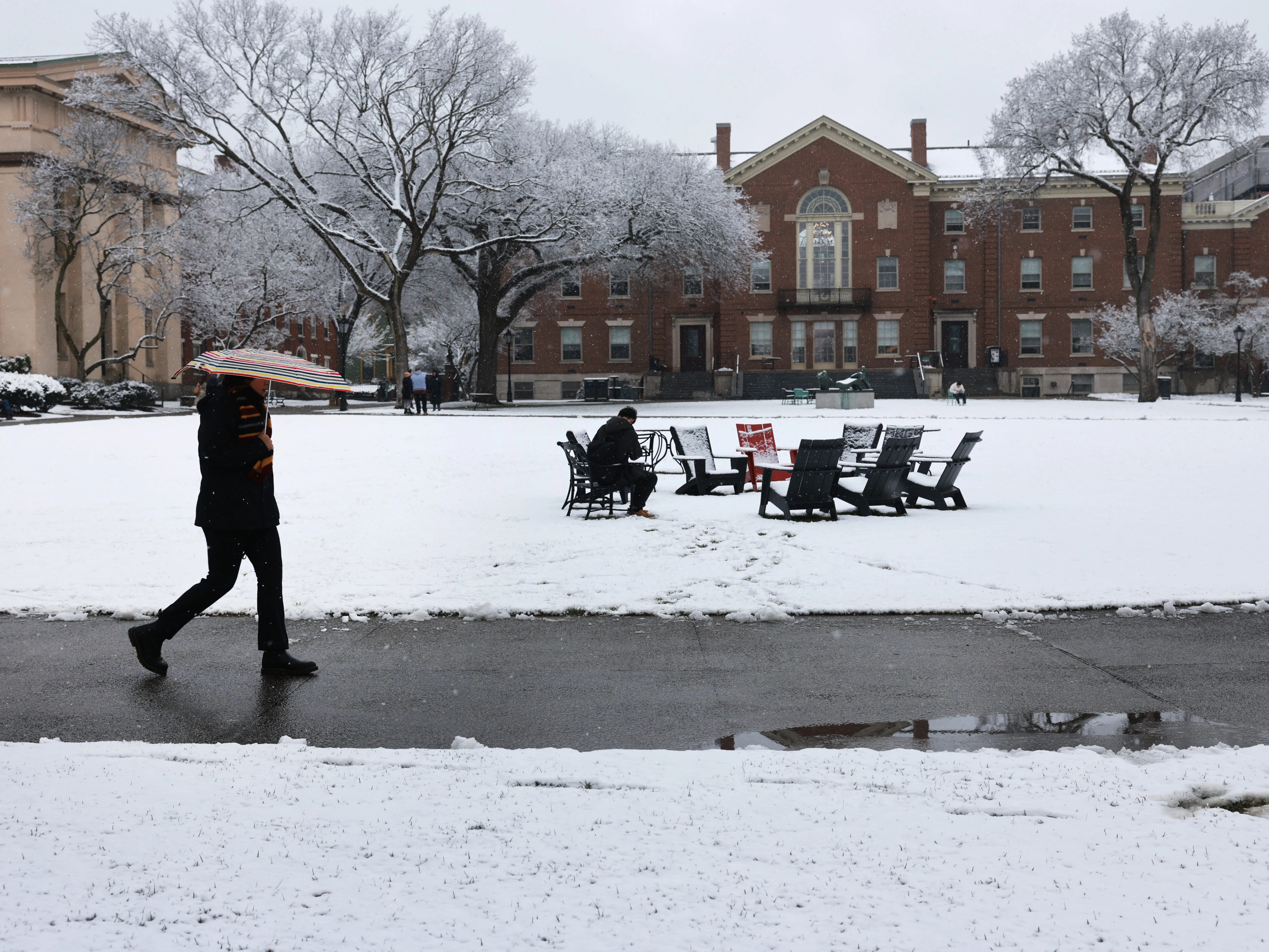 Students walk on a snow-covered campus.