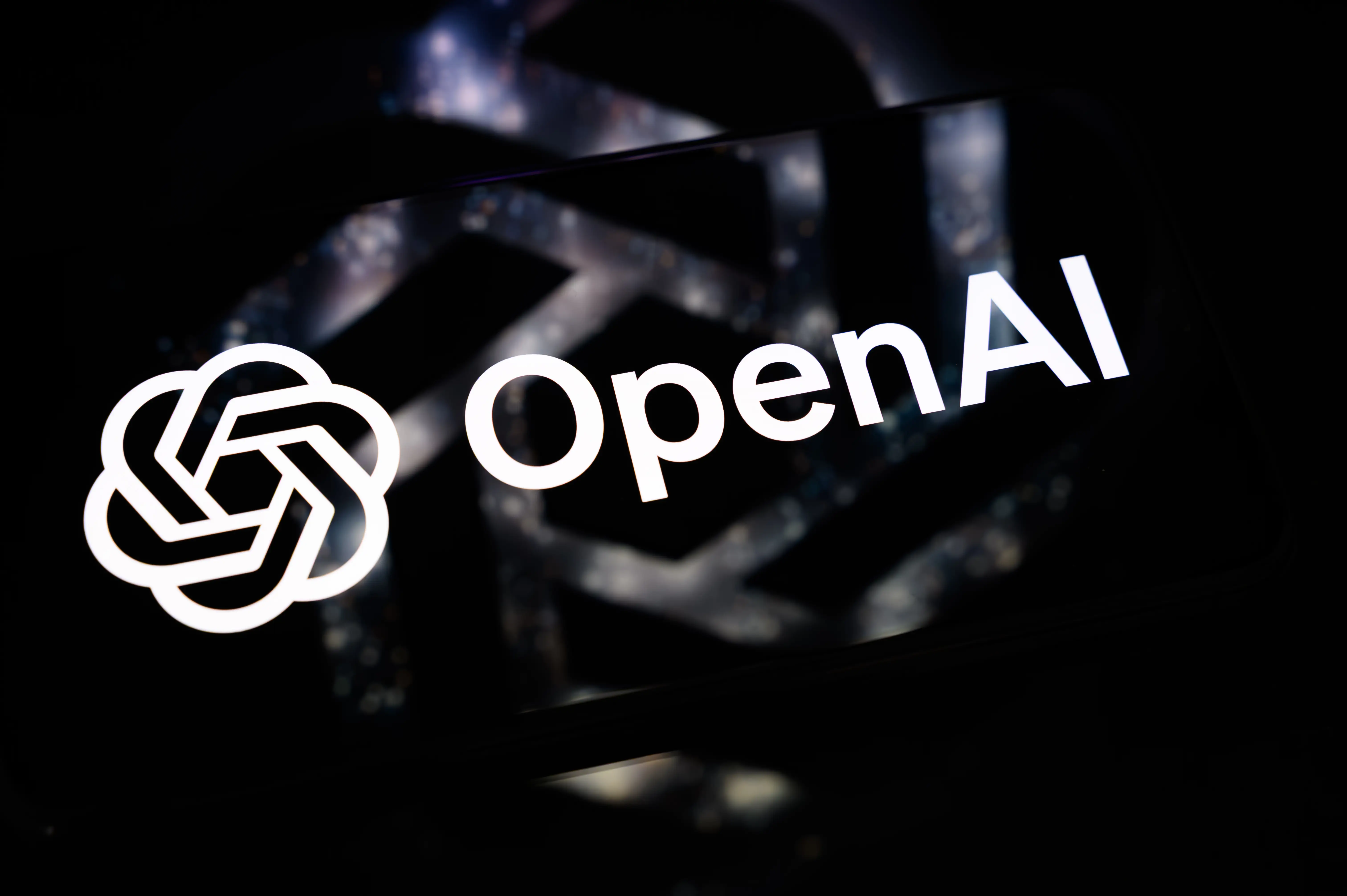 OpenAI logo and wordmark appear in white against a dark blurred background.