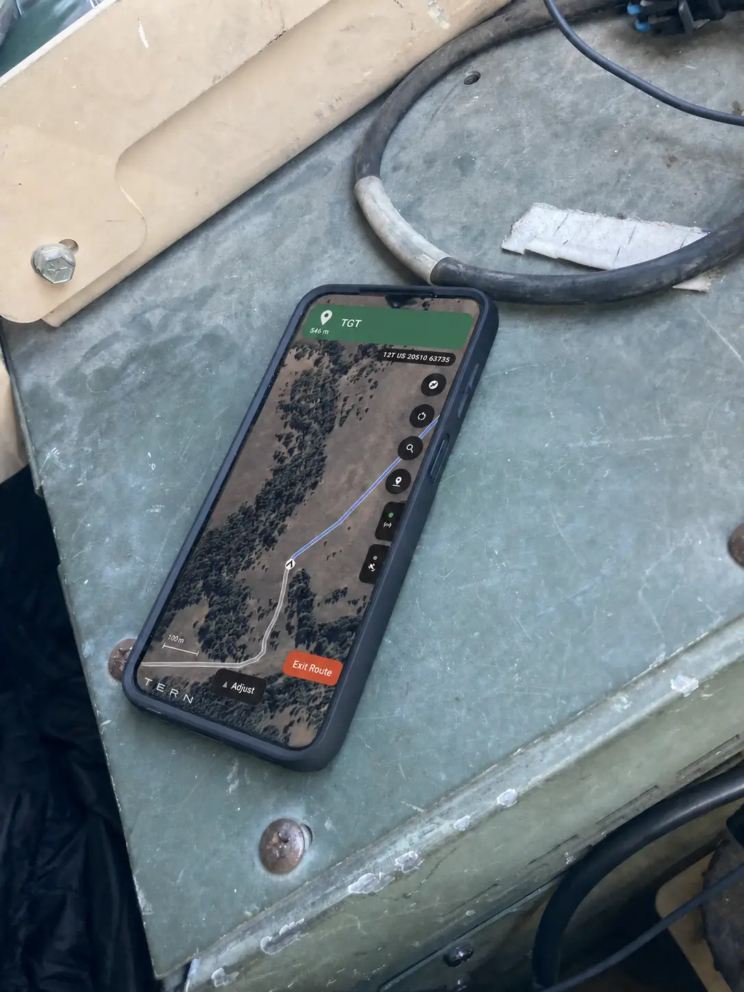 A smartphone sitting inside a vehicle with a map shown on the screen.