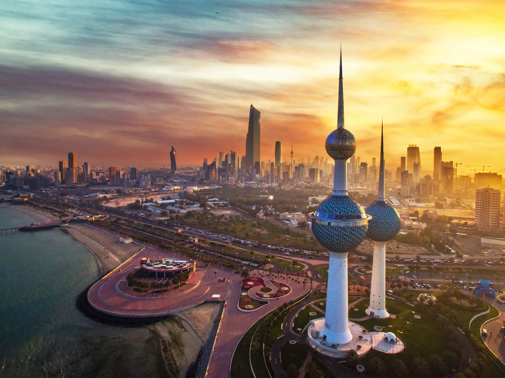 Kuwait Towers rise above Kuwait City’s waterfront skyline during a golden sunset.