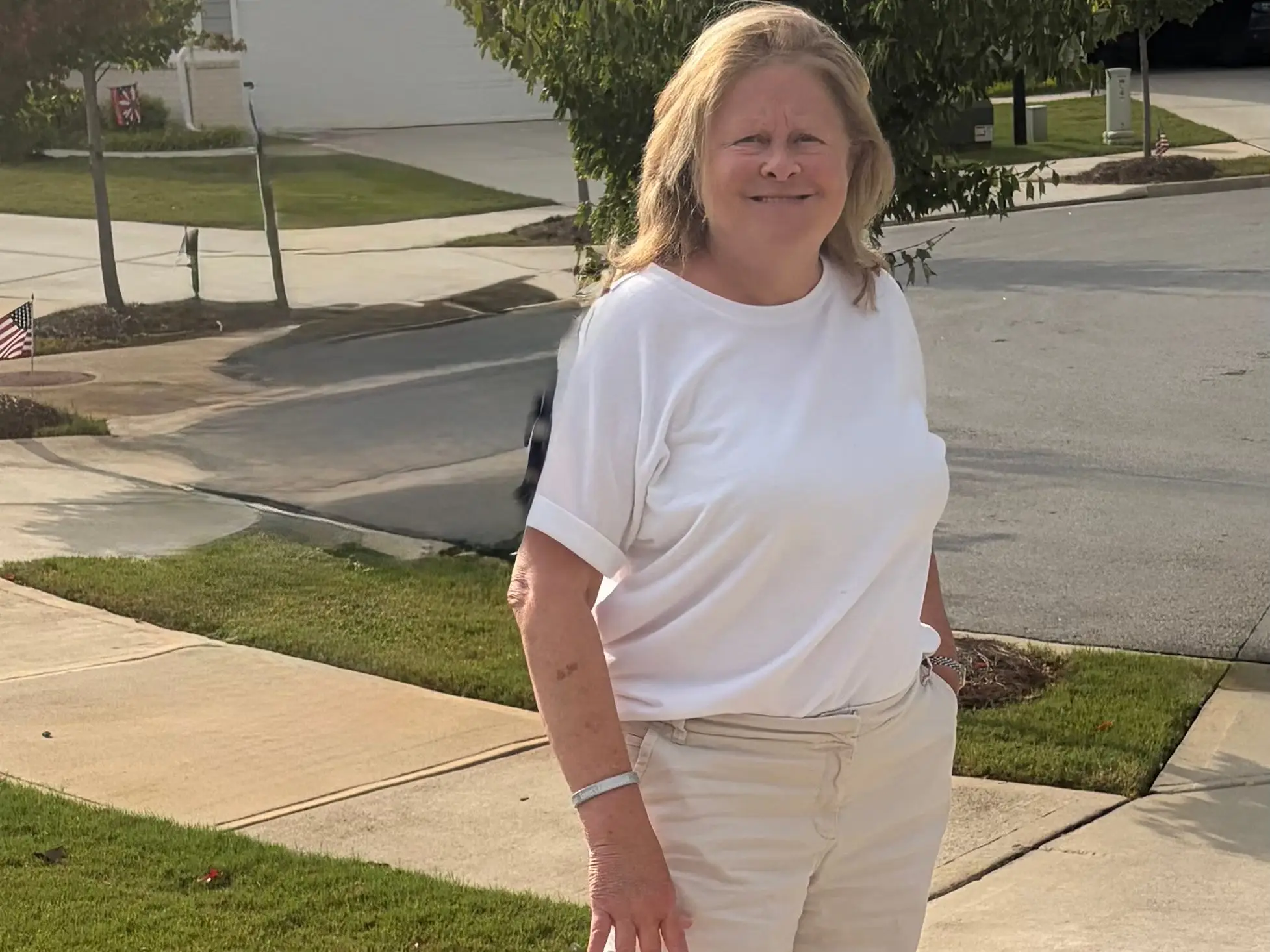 A woman wearing cream shorts and a white T-shirt