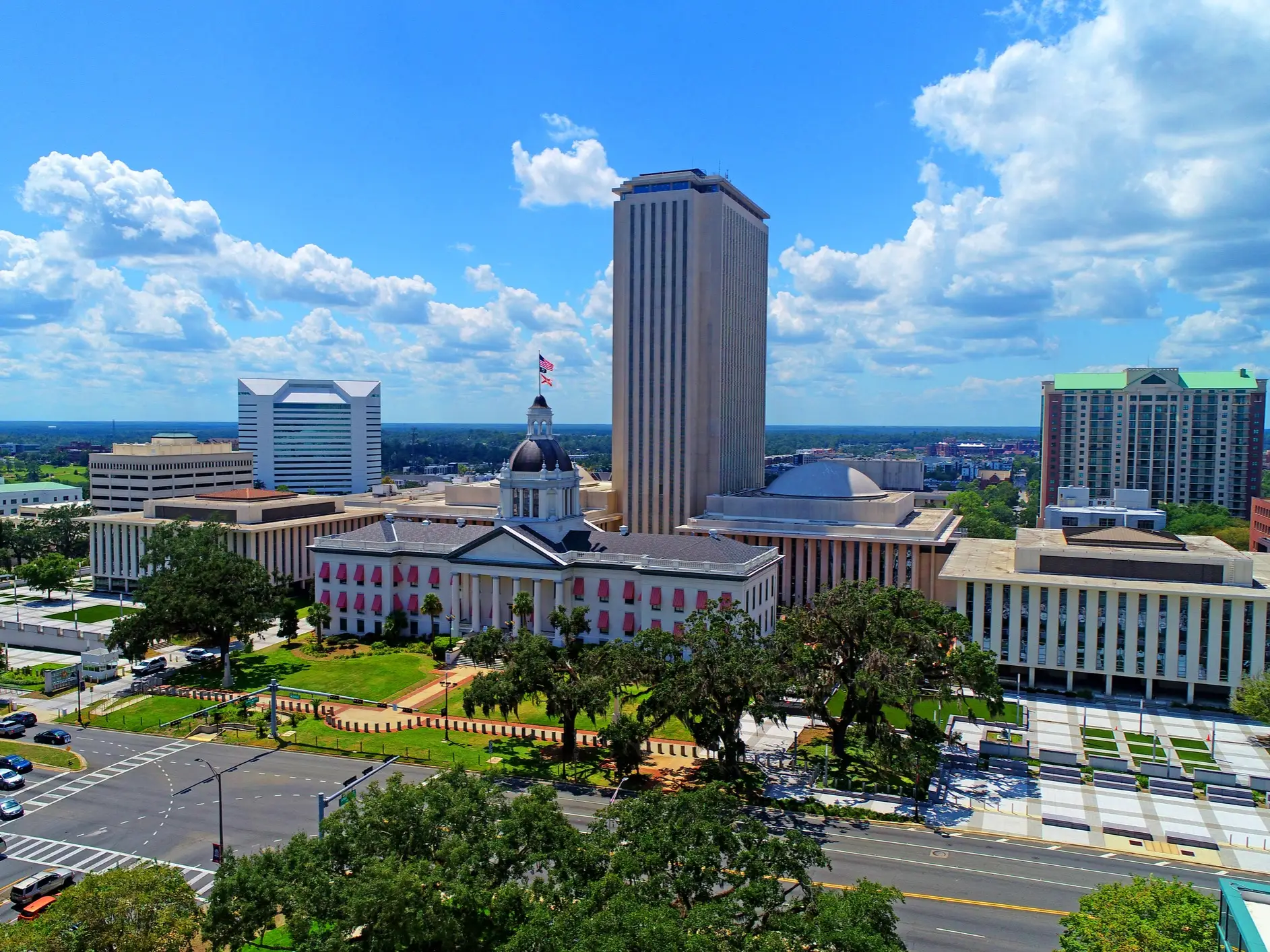Florida State Capitol complex in Tallahassee with the historic domed capitol, tower, streets, and blue sky.