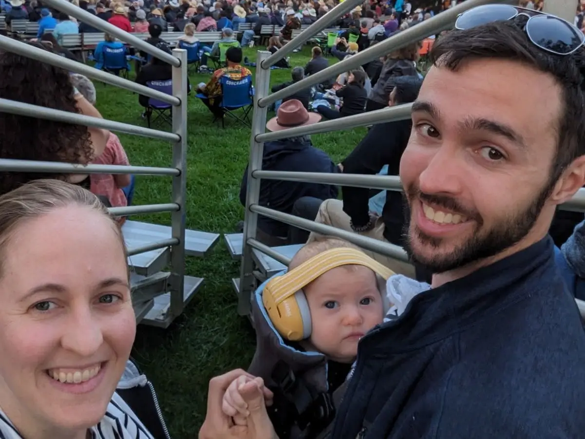 The author and her partner with their young baby at an outdoor concert.