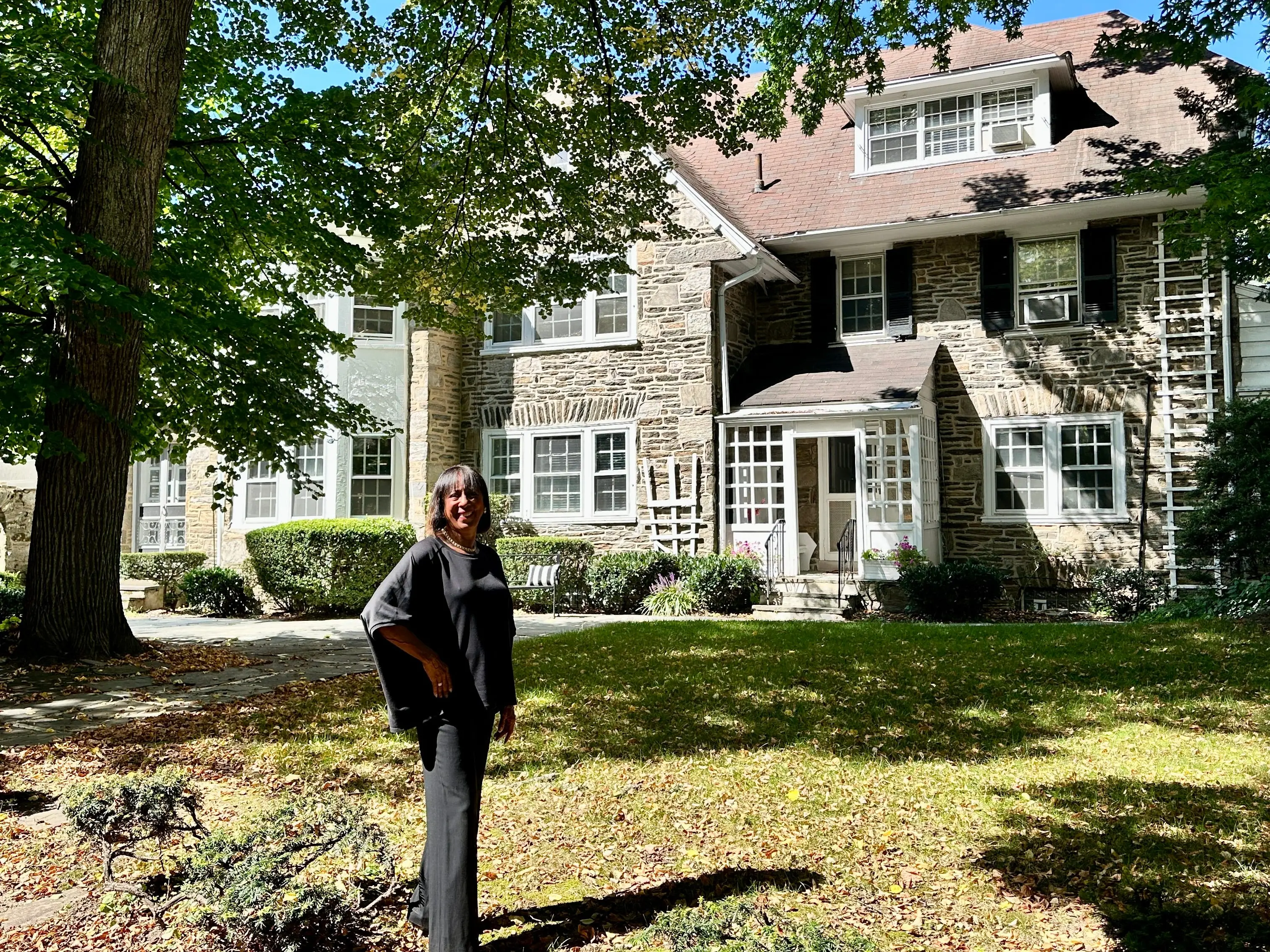 A real estate agent standing outside a brick house.