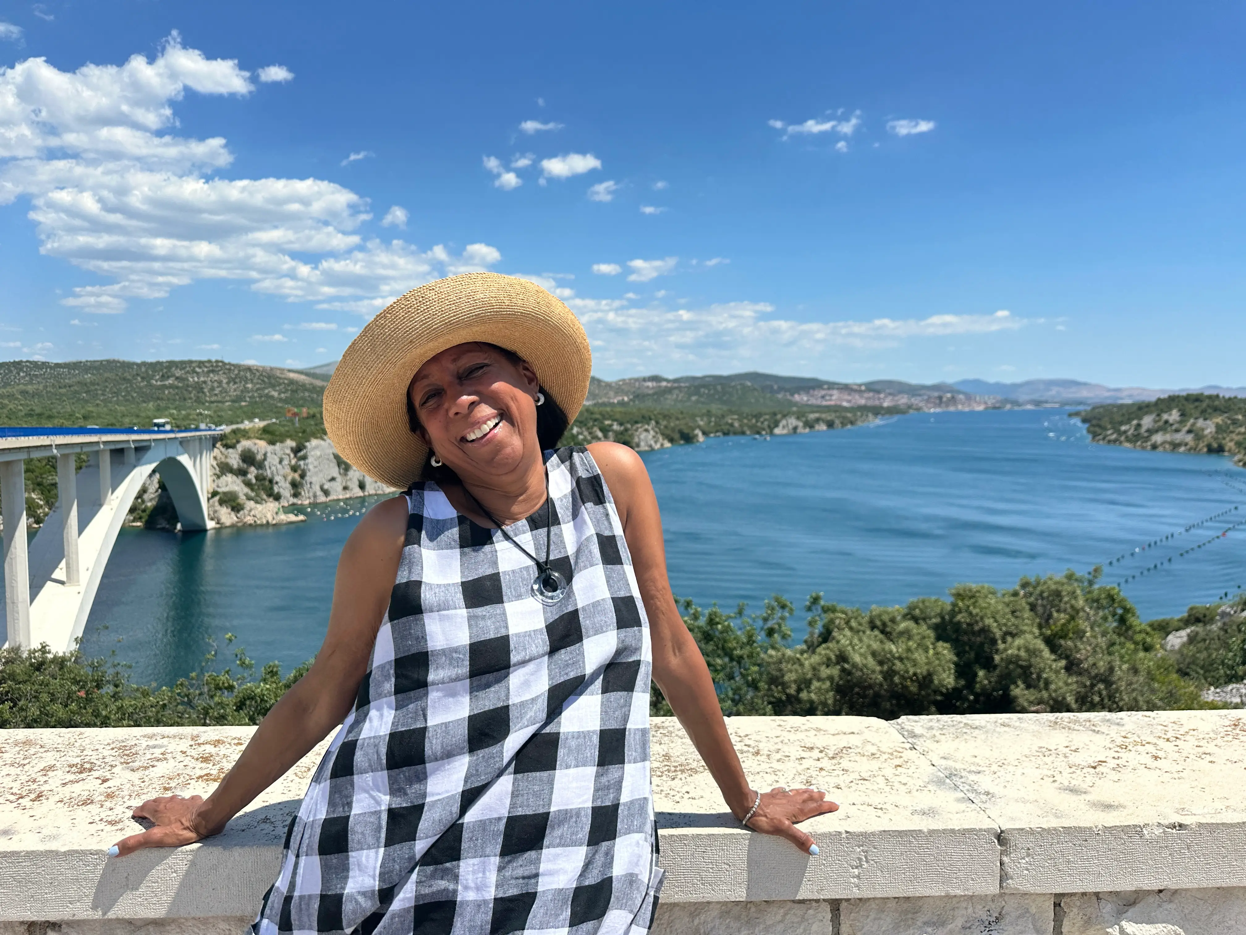 A woman wearing a hat with a waterway behind her.