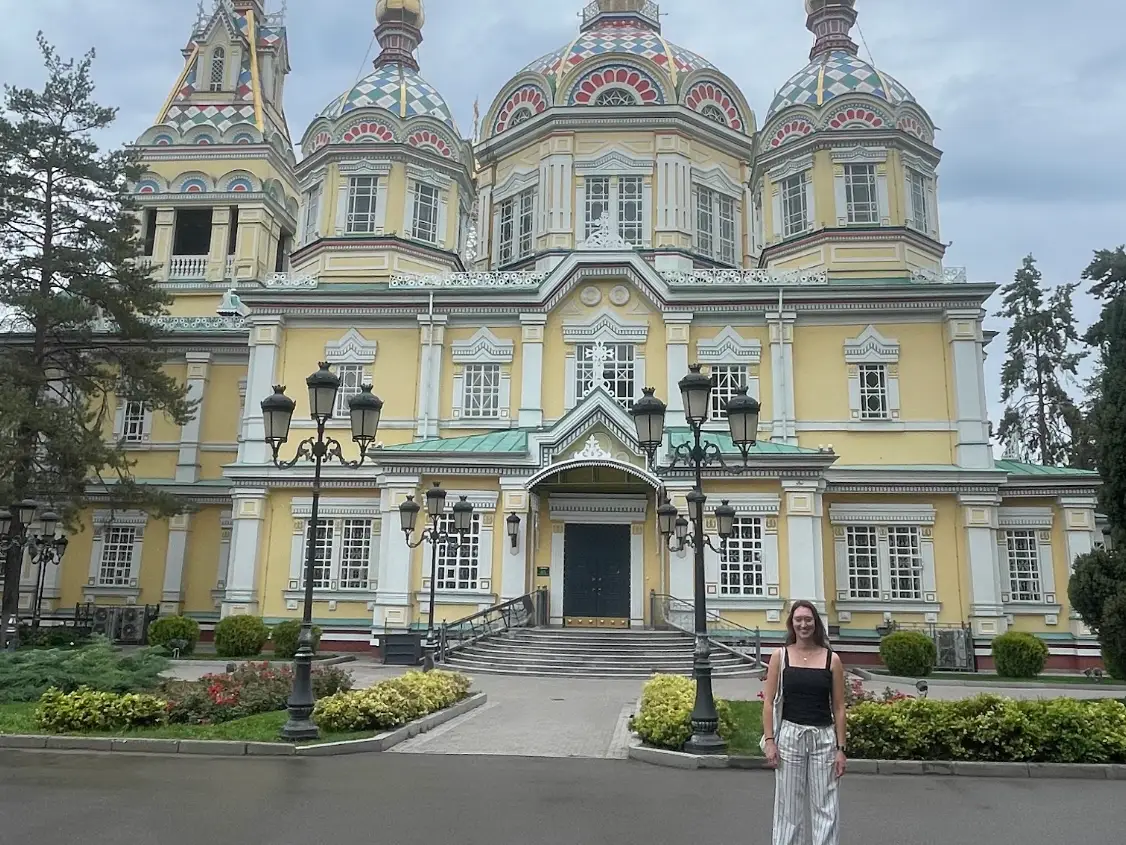 The writer standing in front of an ornate building in Almaty.