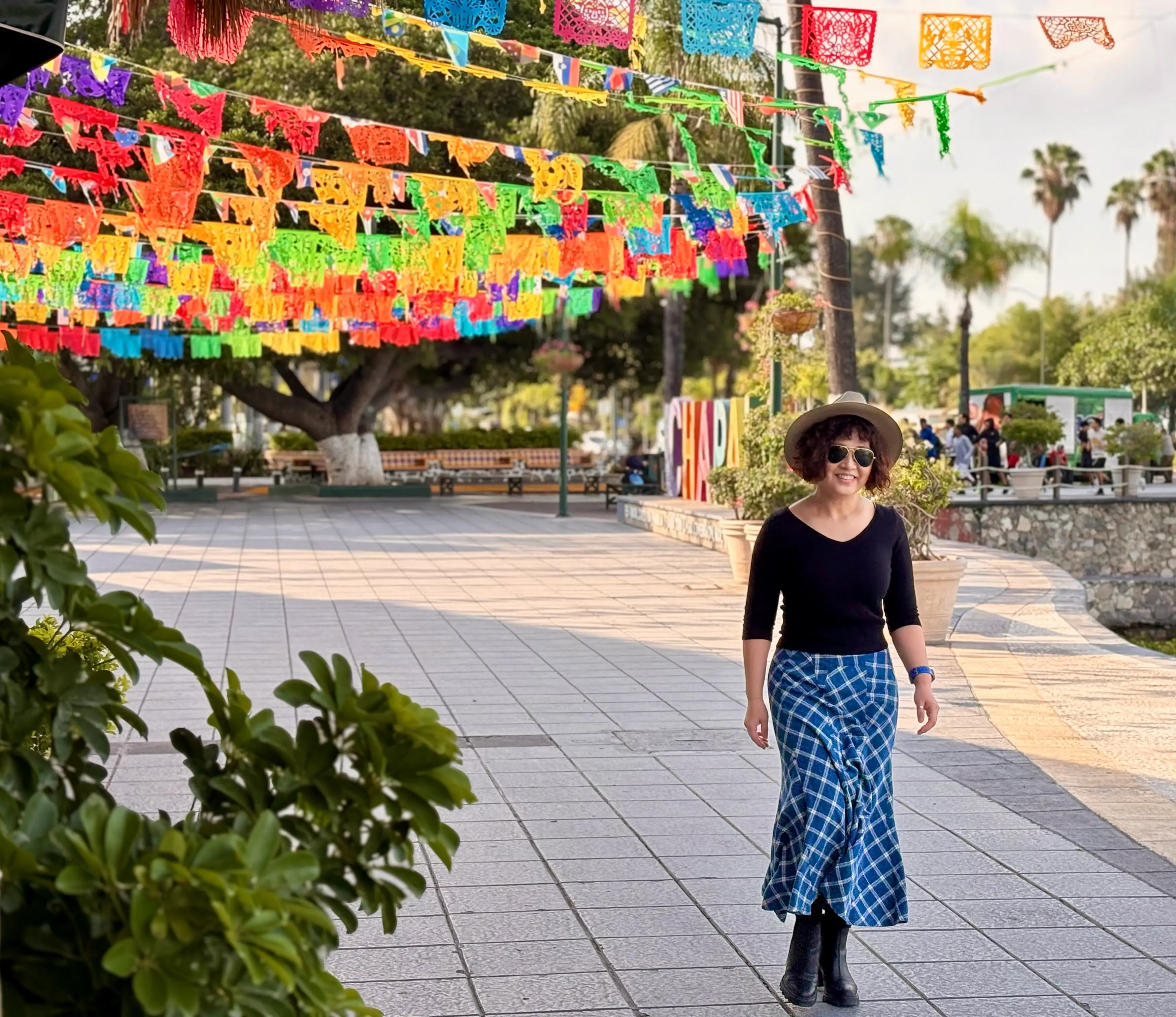 Woman smiling on beach under colorful flag banners