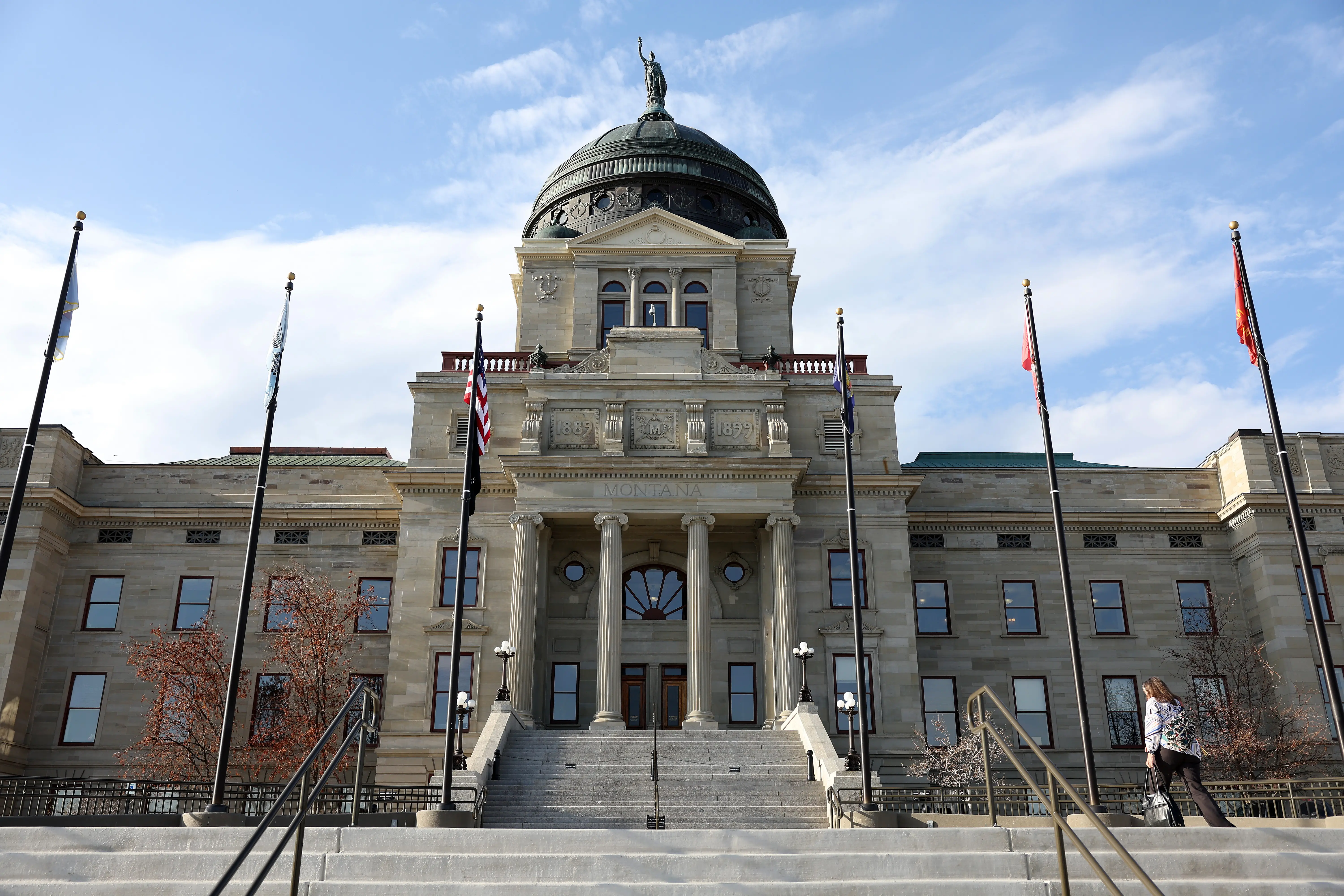 A person walks up the steps of the Montana State Capitol building.