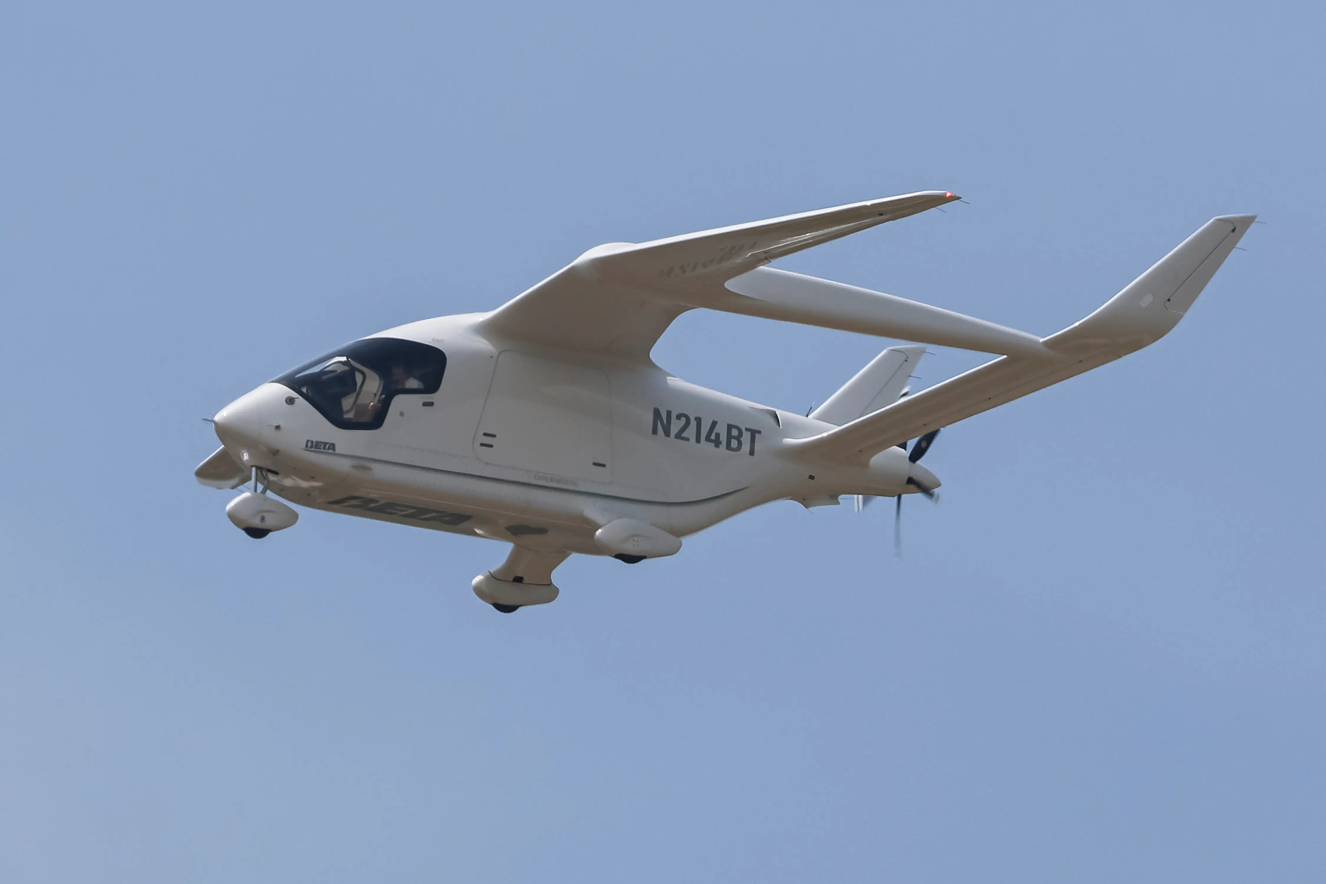 A white all-electric Alia CX300 flying in the air.