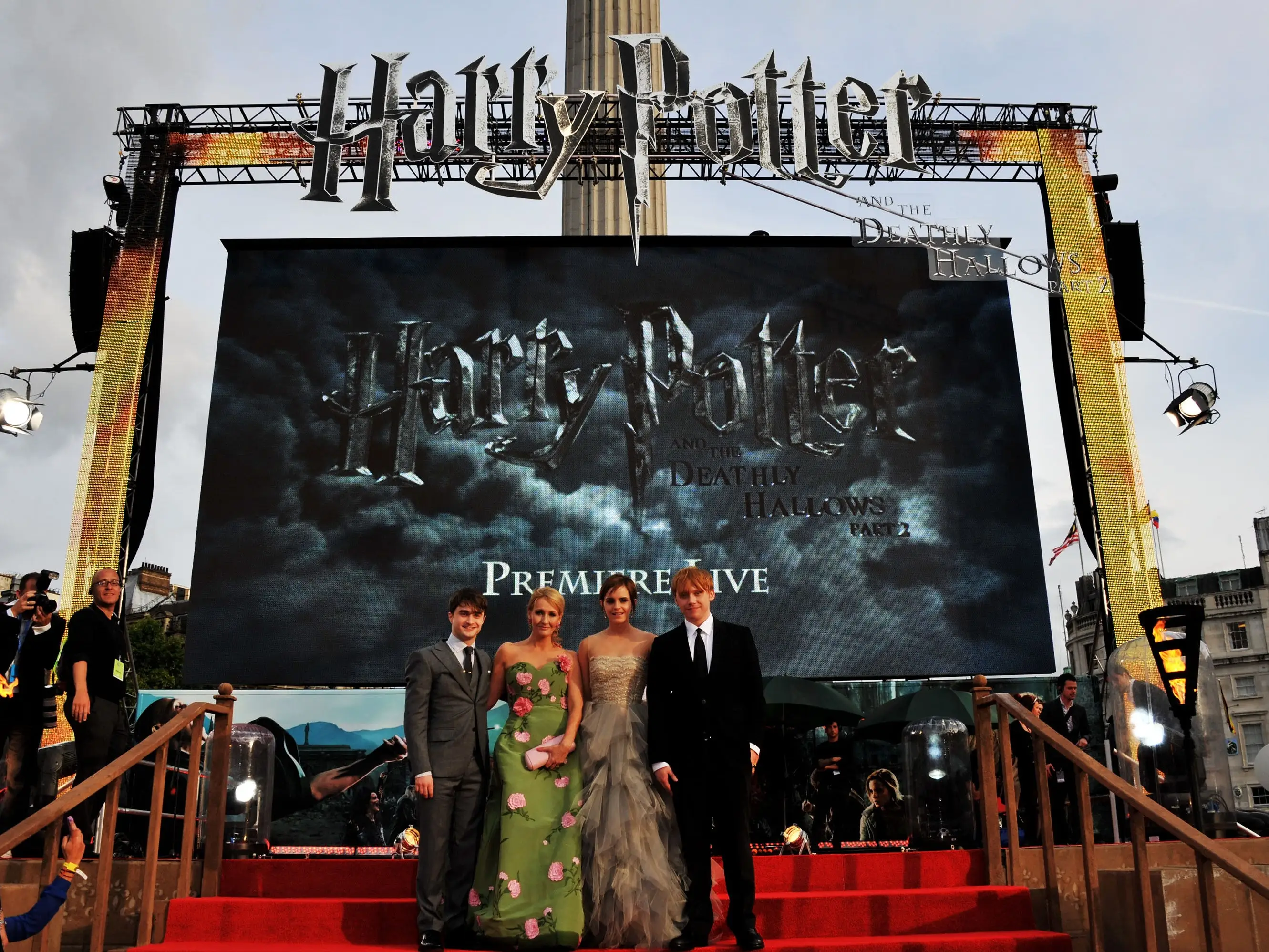 Four people stand before a large Harry Potter sign on the red carpet.