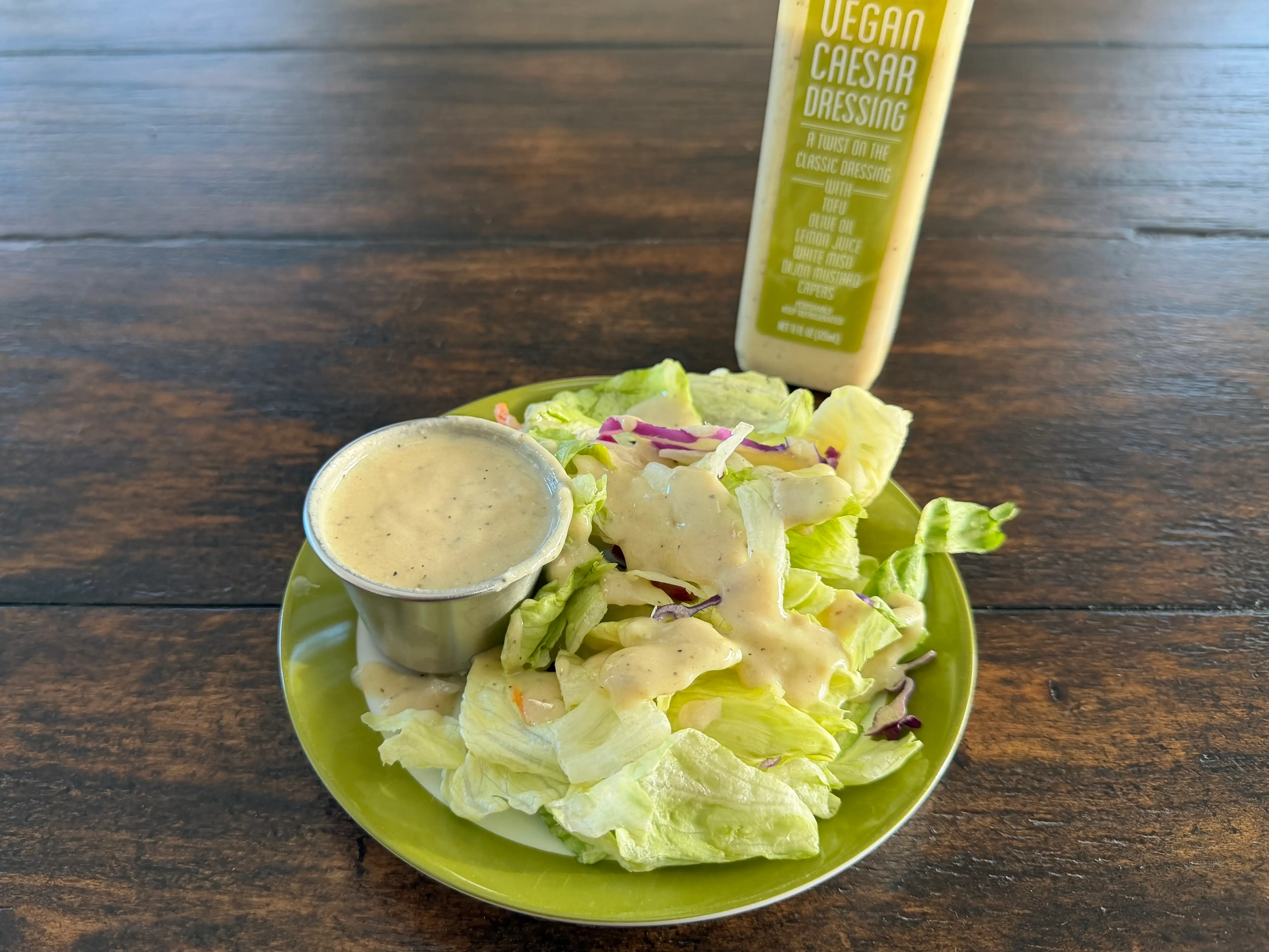 Trader Joe's Caesar dressing bottle next to small salad