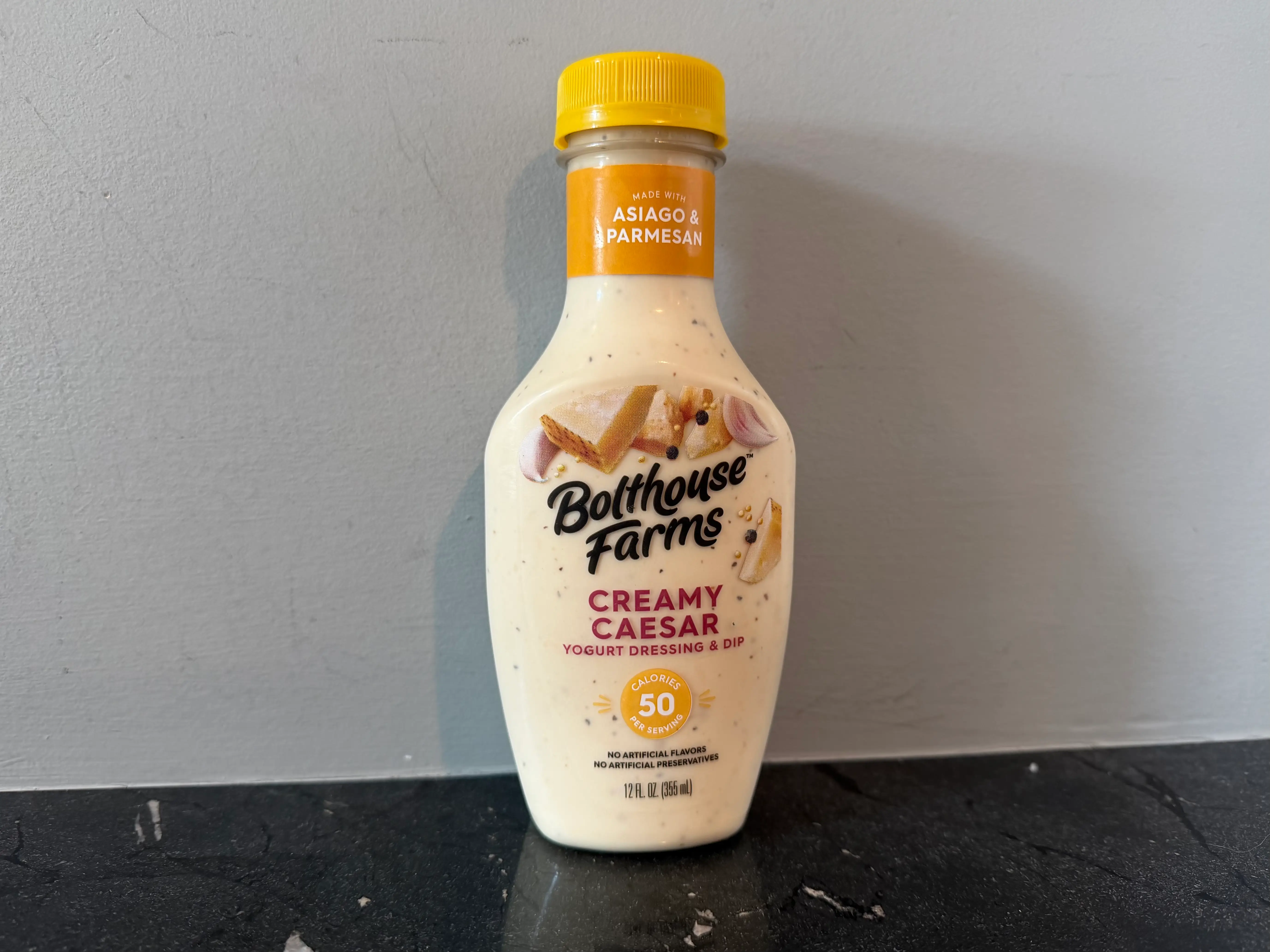 Bolthouse Farms Caesar dressing bottle next to small salad