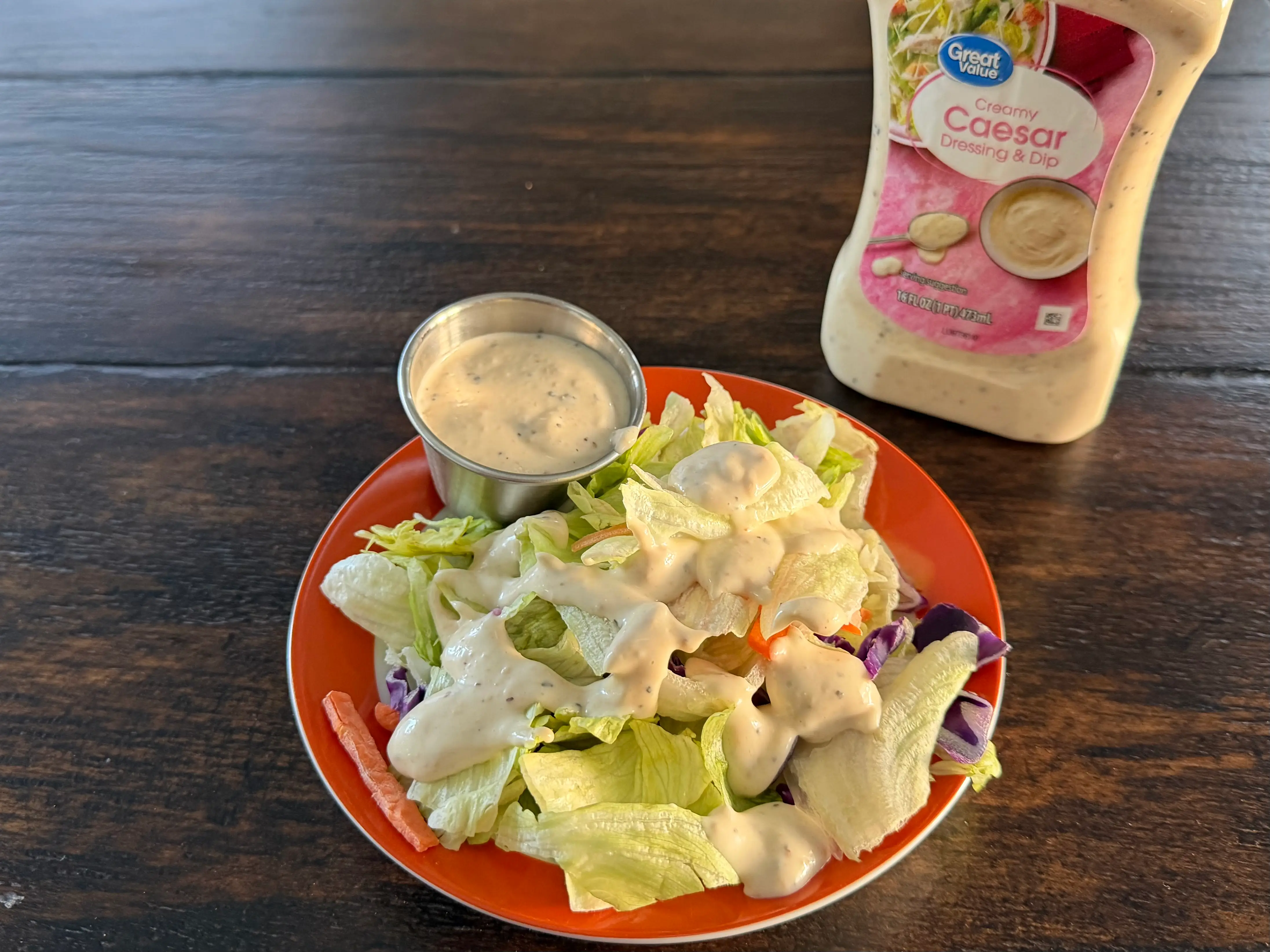 Great Value Caesar dressing bottle next to small salad
