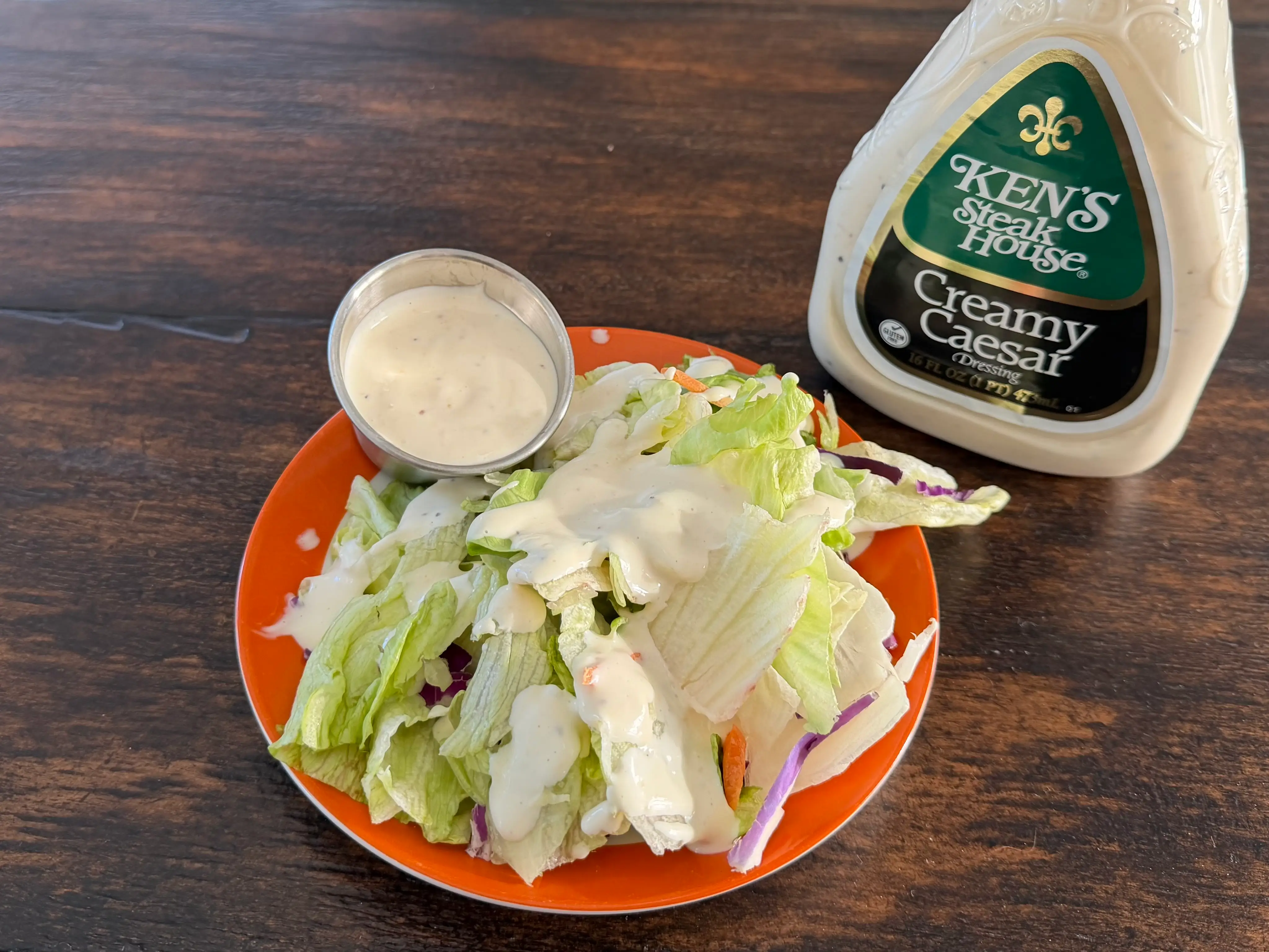 Ken's Steakouse Caesar dressing bottle next to small salad