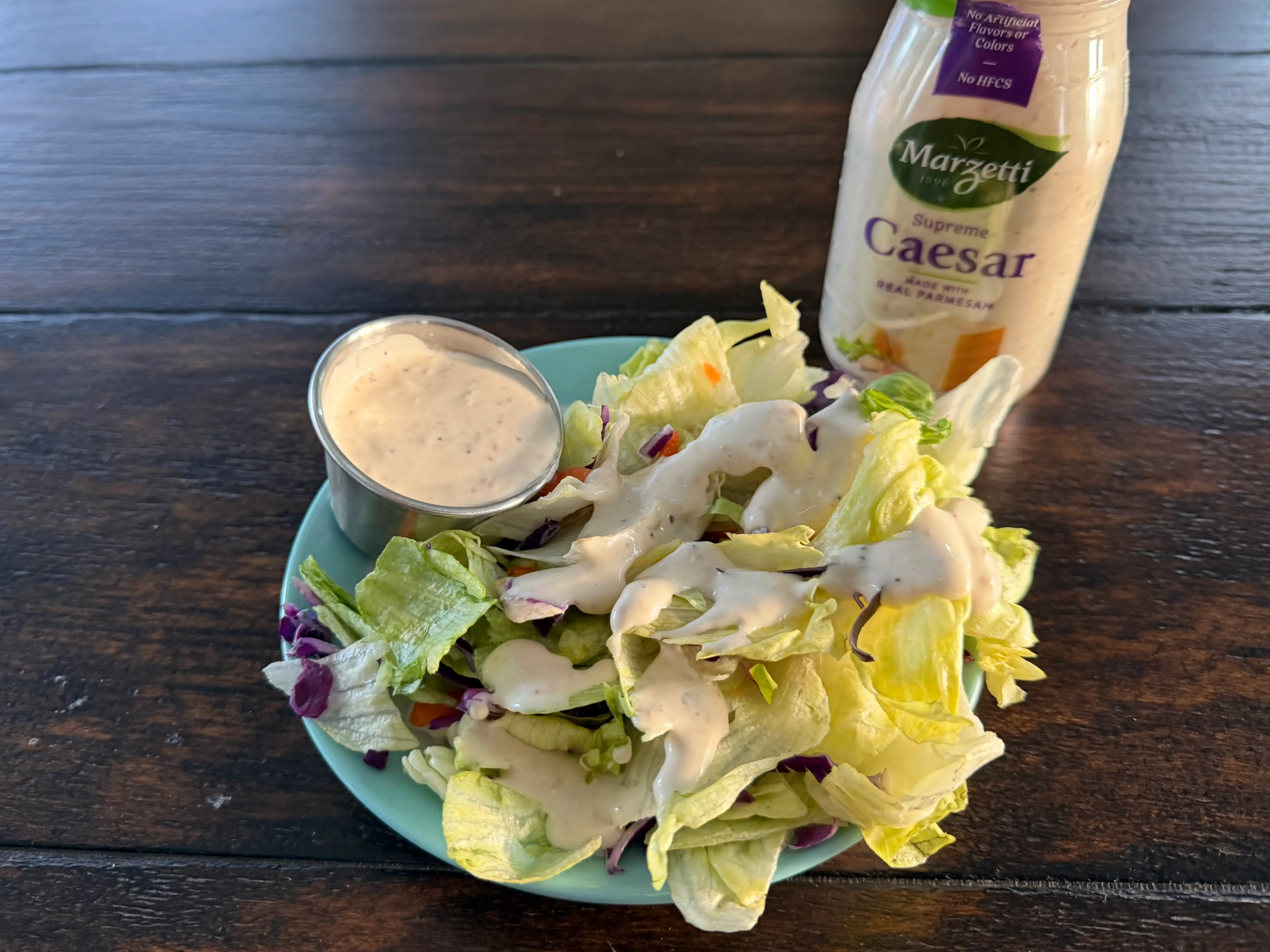 Marzetti Caesar dressing bottle next to small salad