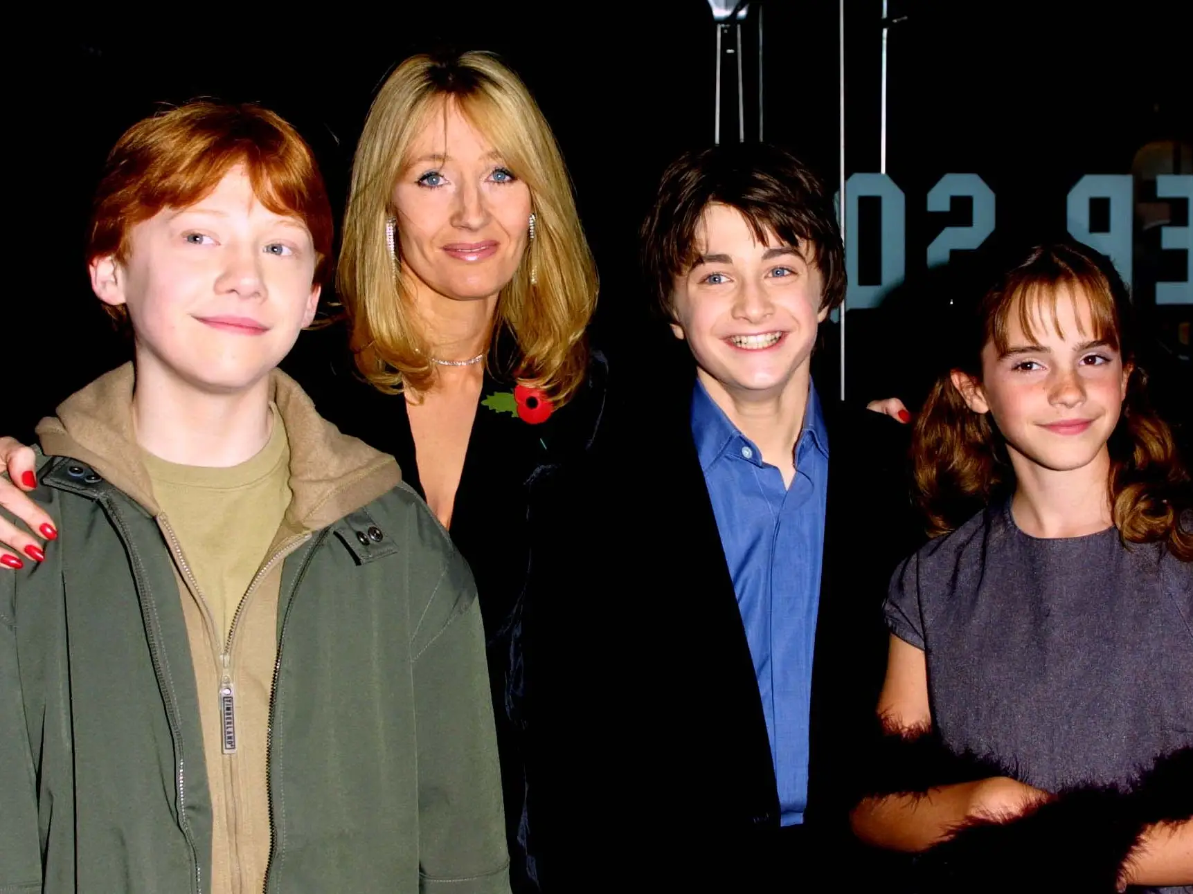 Four people smile at a movie premiere.