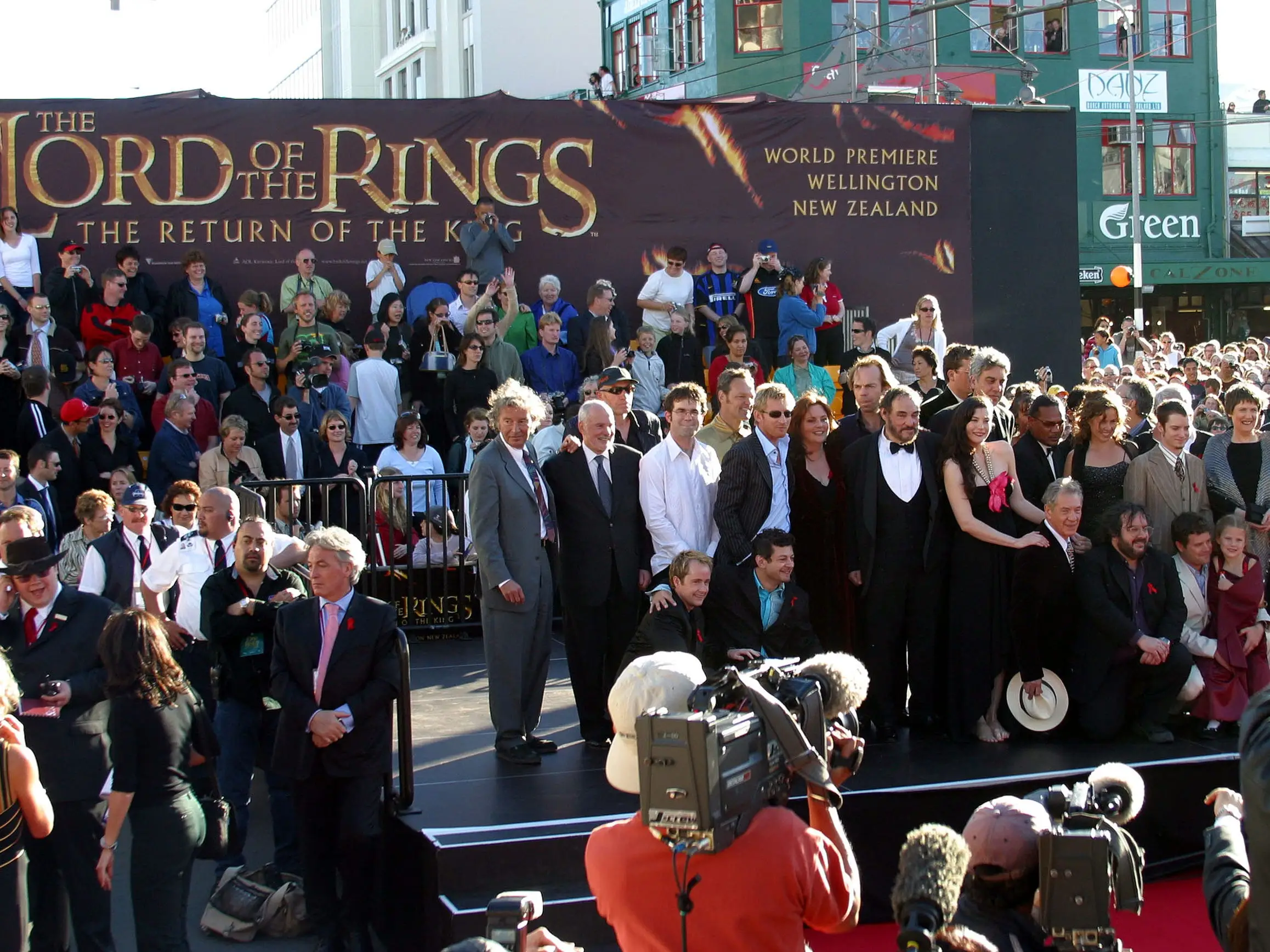 A cast of a movie pose before cameras.