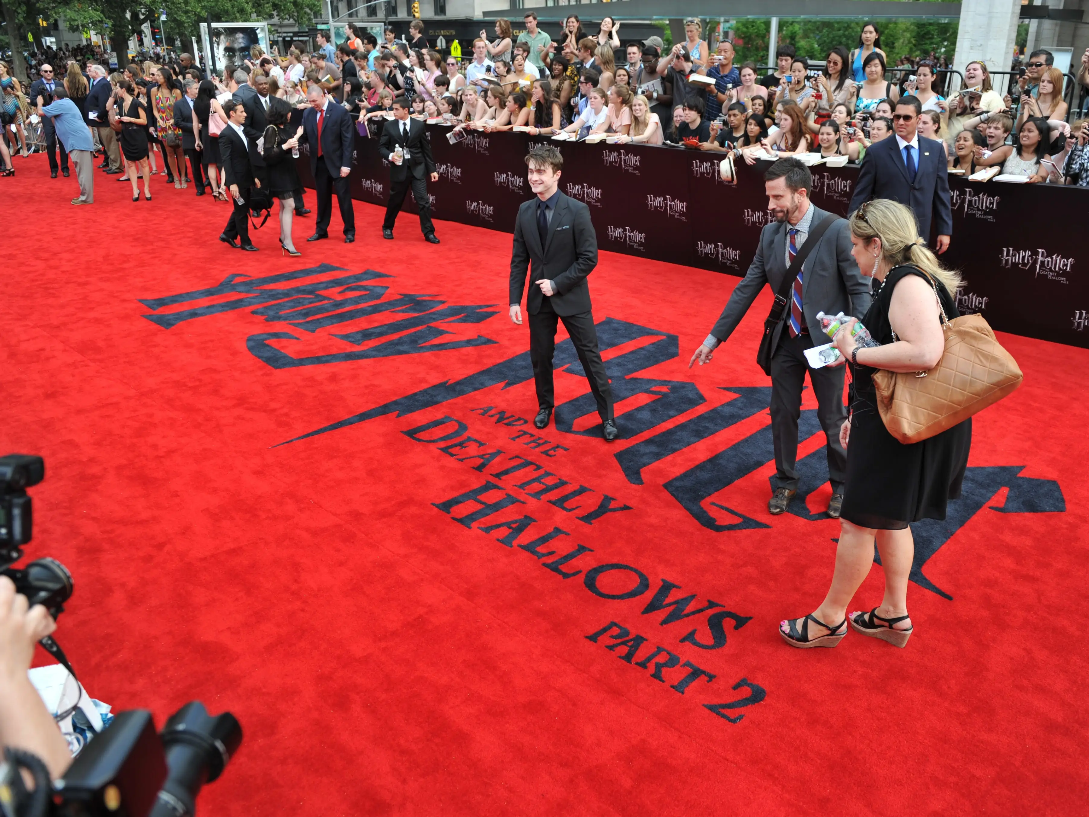 An actor stands on a red carpet.