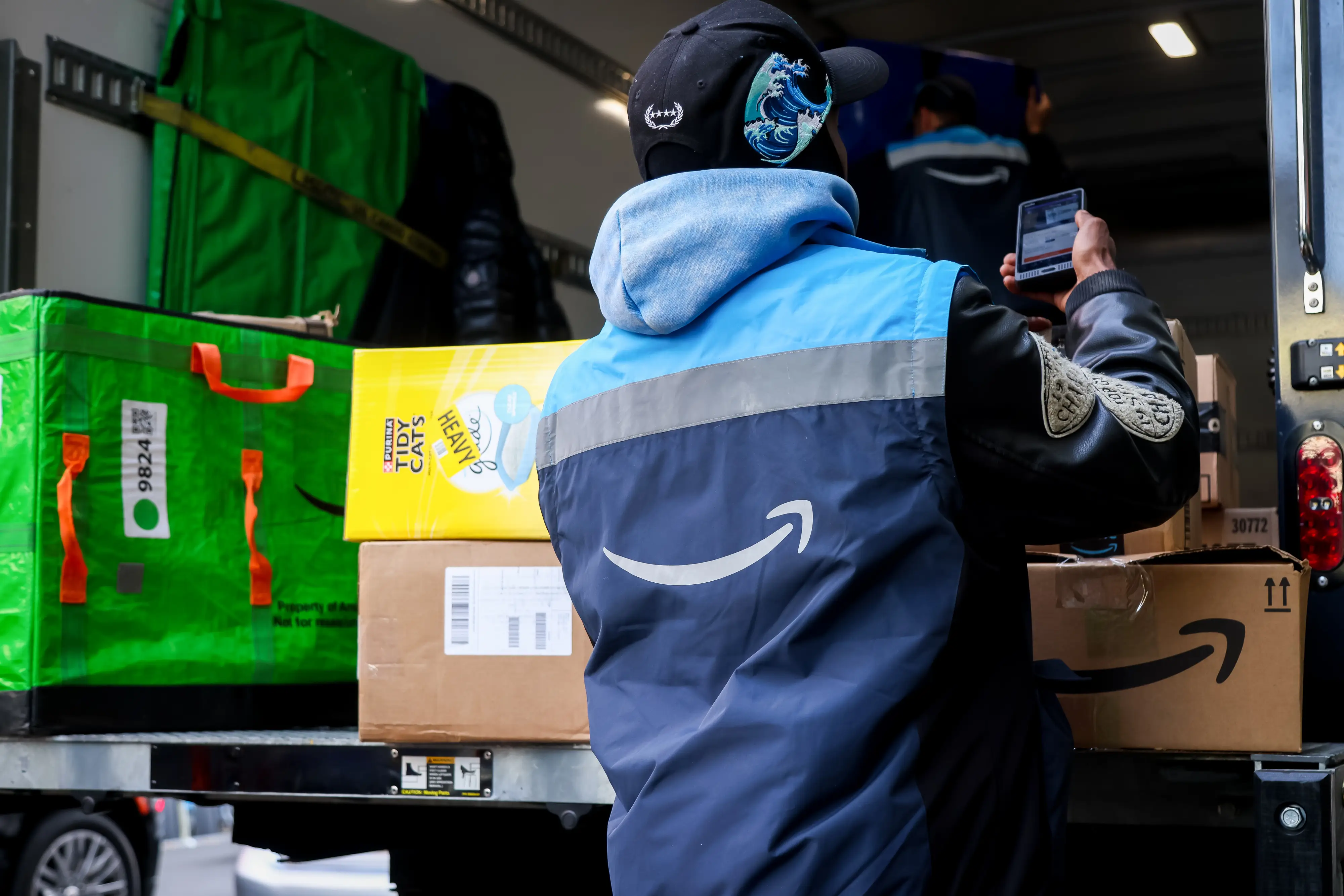A worker scans an Amazon package on a Prime delivery truck in New York