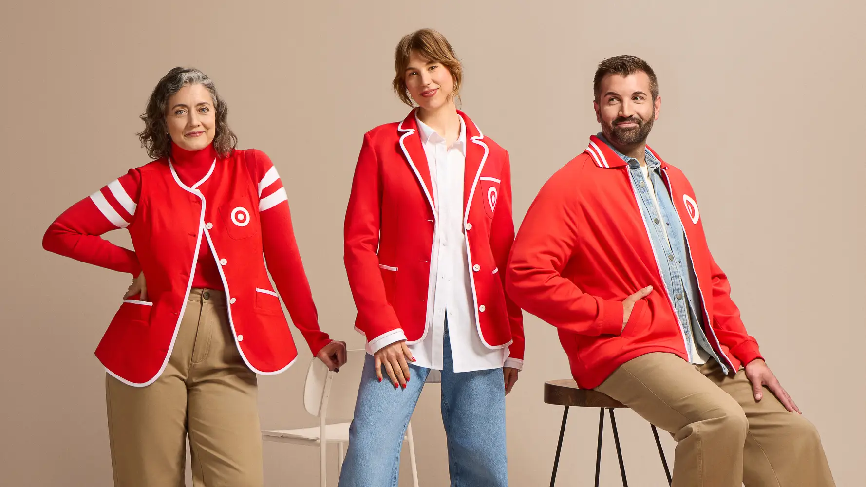 Three people pose in red Target-branded apparel against a beige studio backdrop.