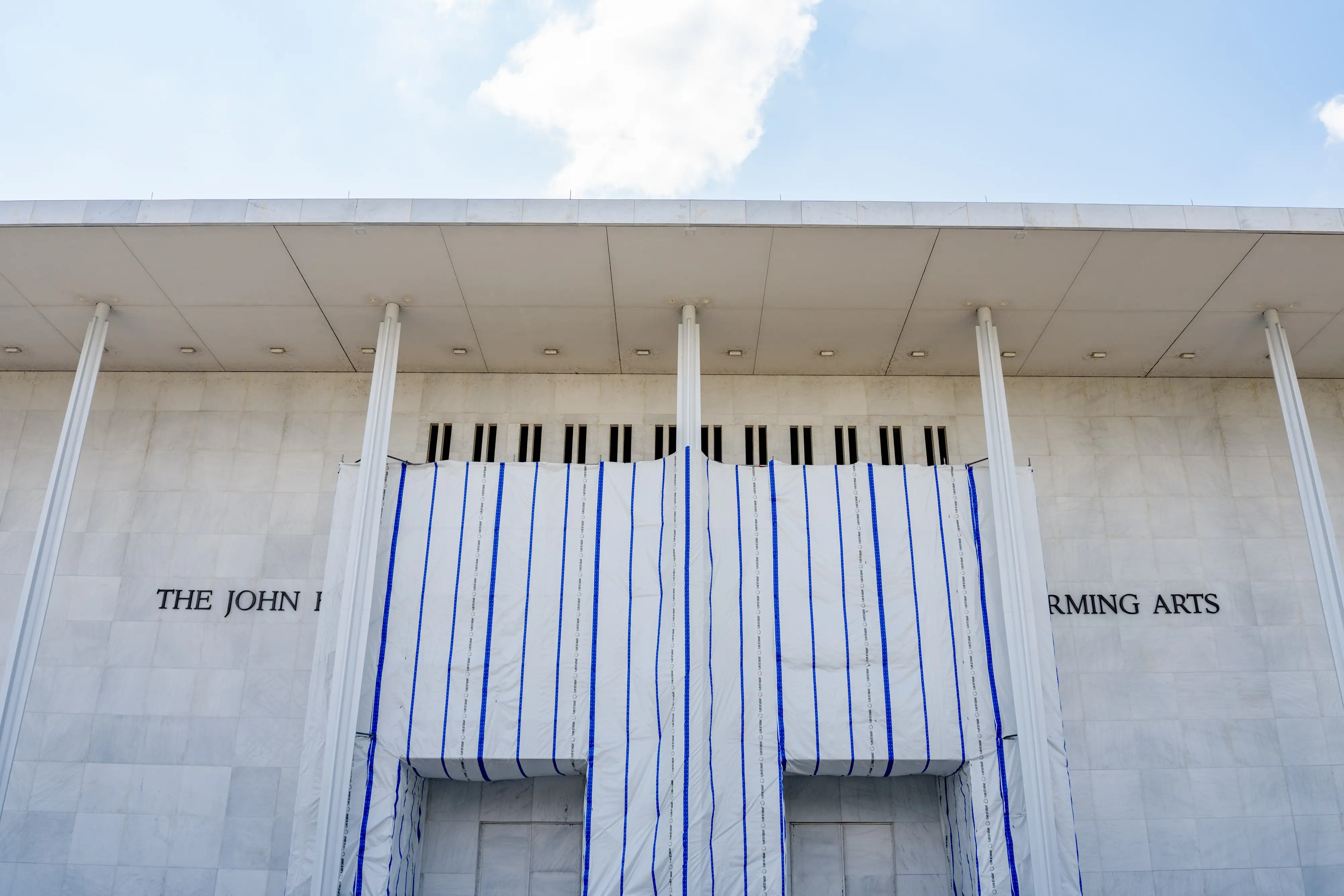 A tarp over the facade of the Kennedy Center.