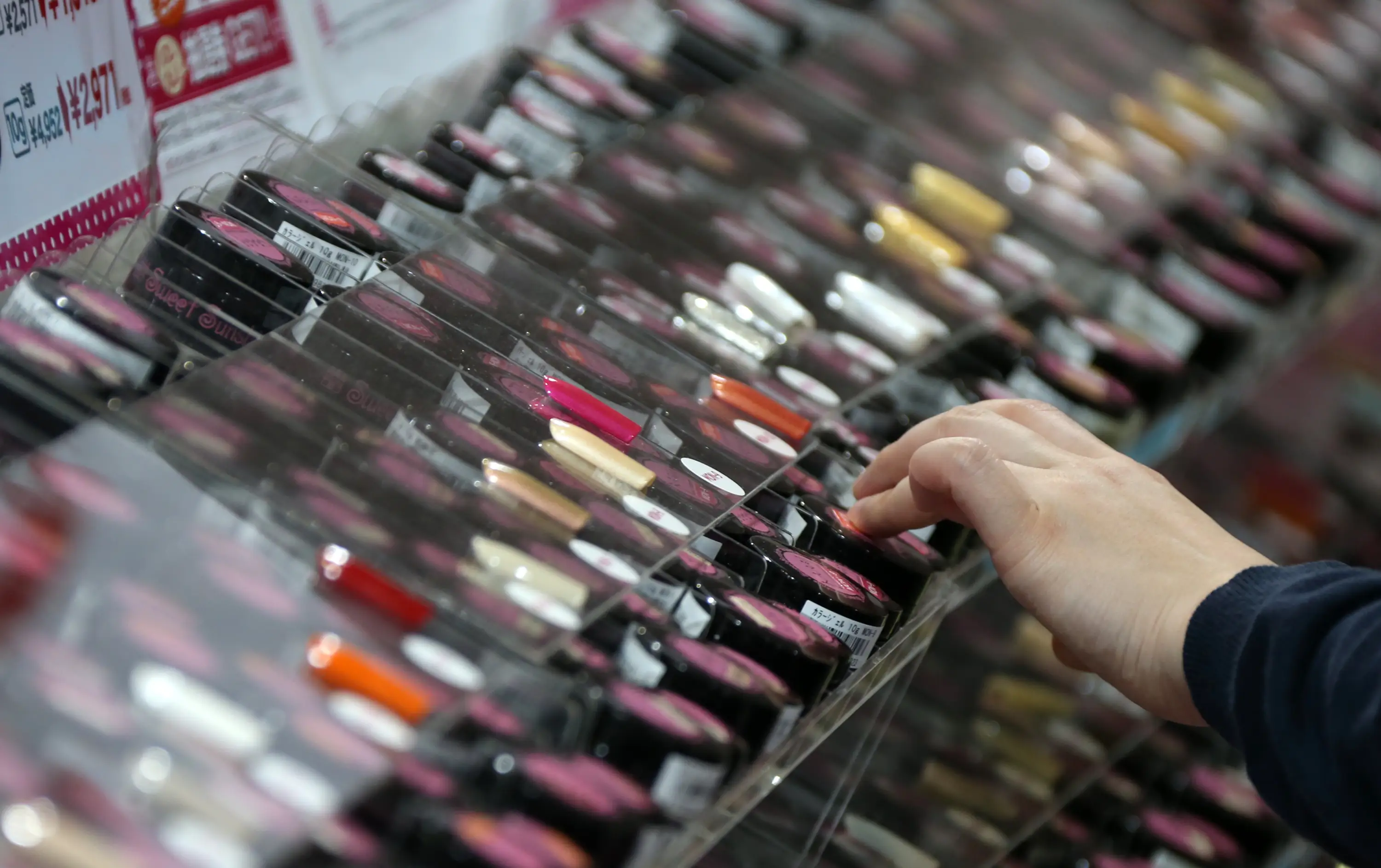 Hand on beauty product display in Japan