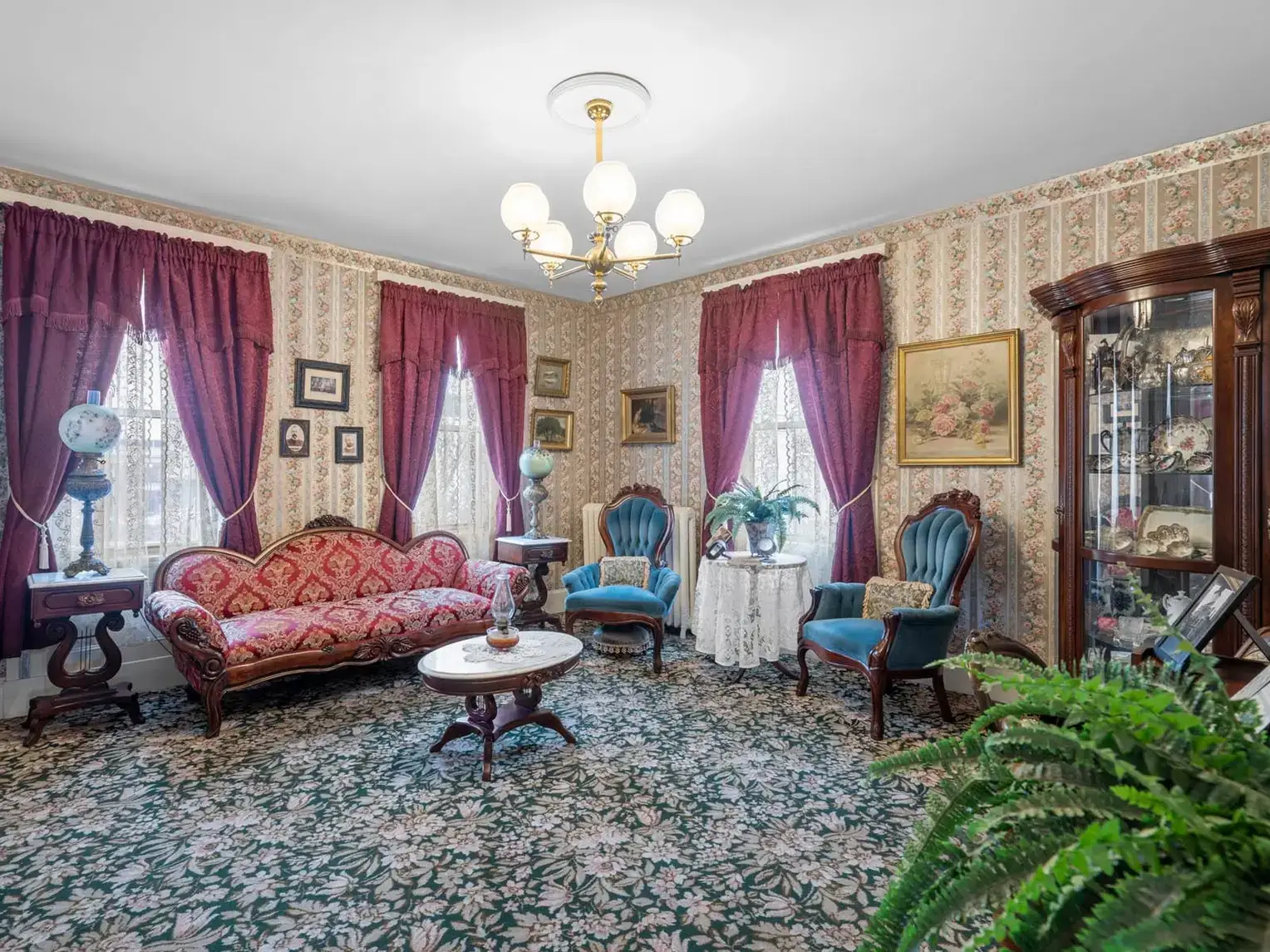 Ornate sitting room with floral wallpaper and patterned carpet.
