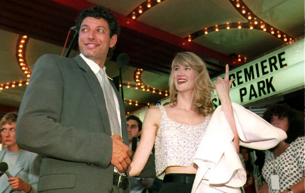 Two actors smile at cameras at a film festival.