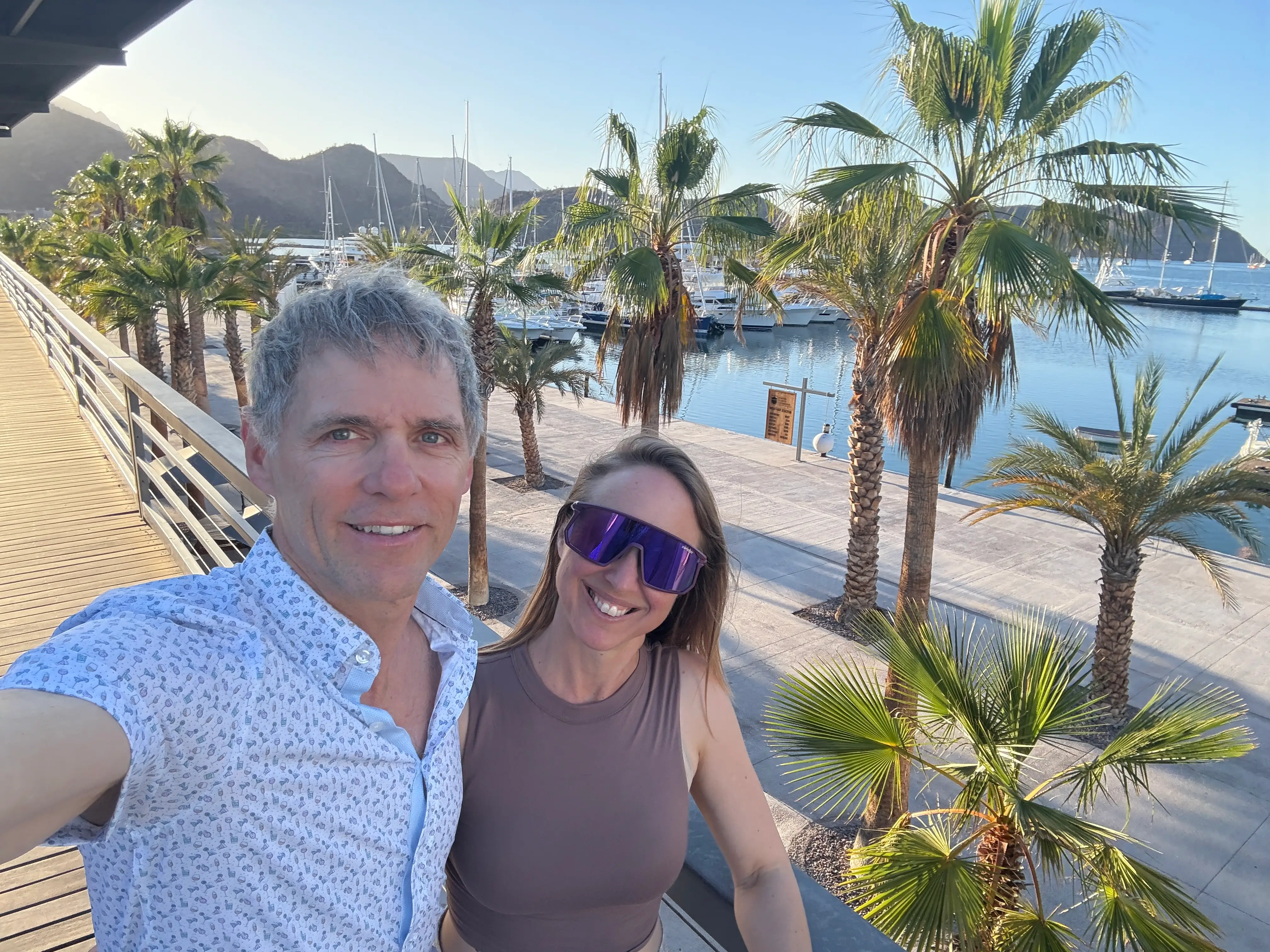 Man and woman smiling near palm trees