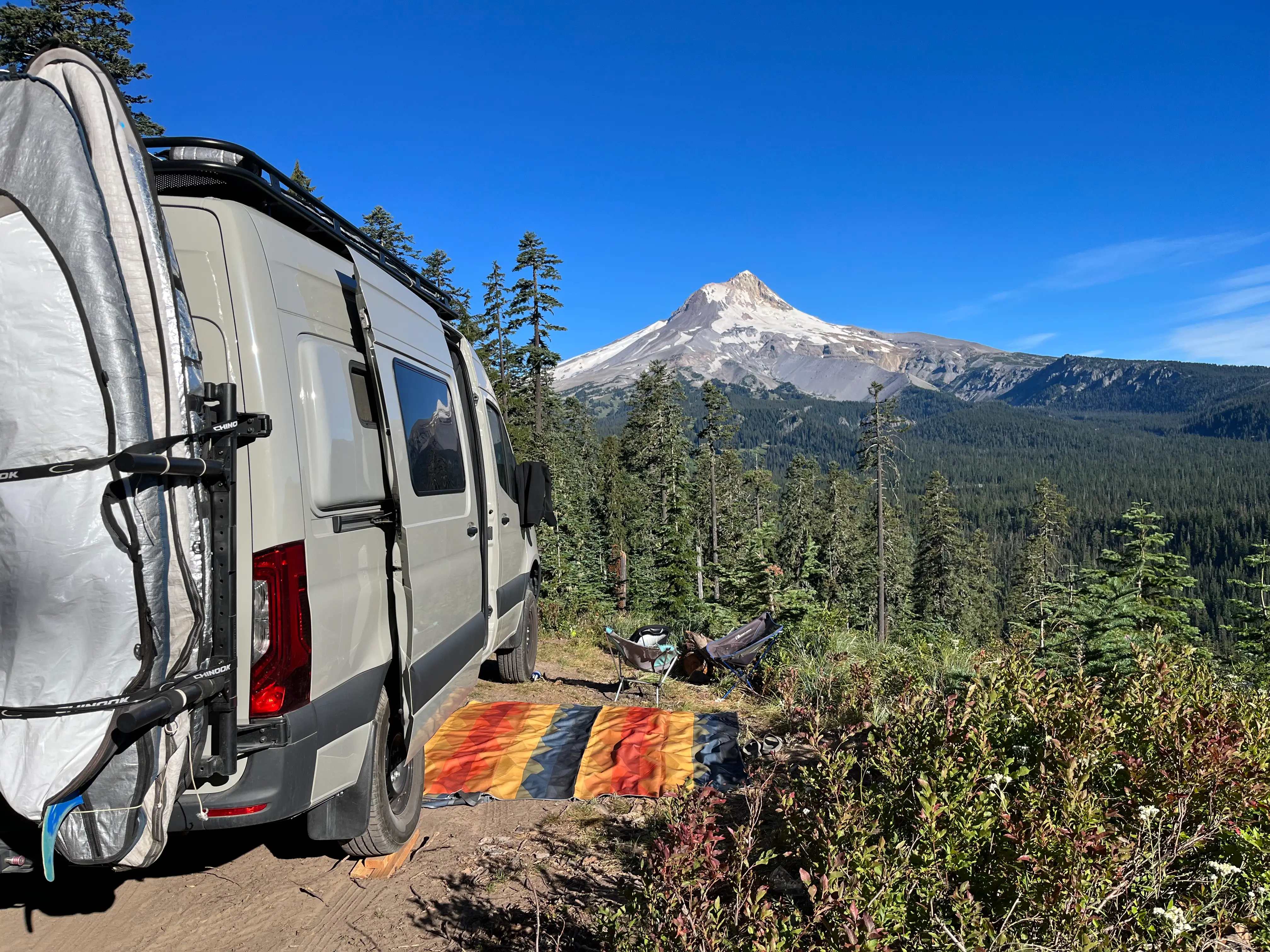 Van with rug next to it, view of mountains behind