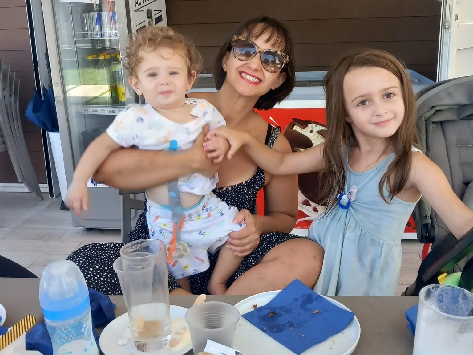 The author poses with her children at a restaurant in Italy.