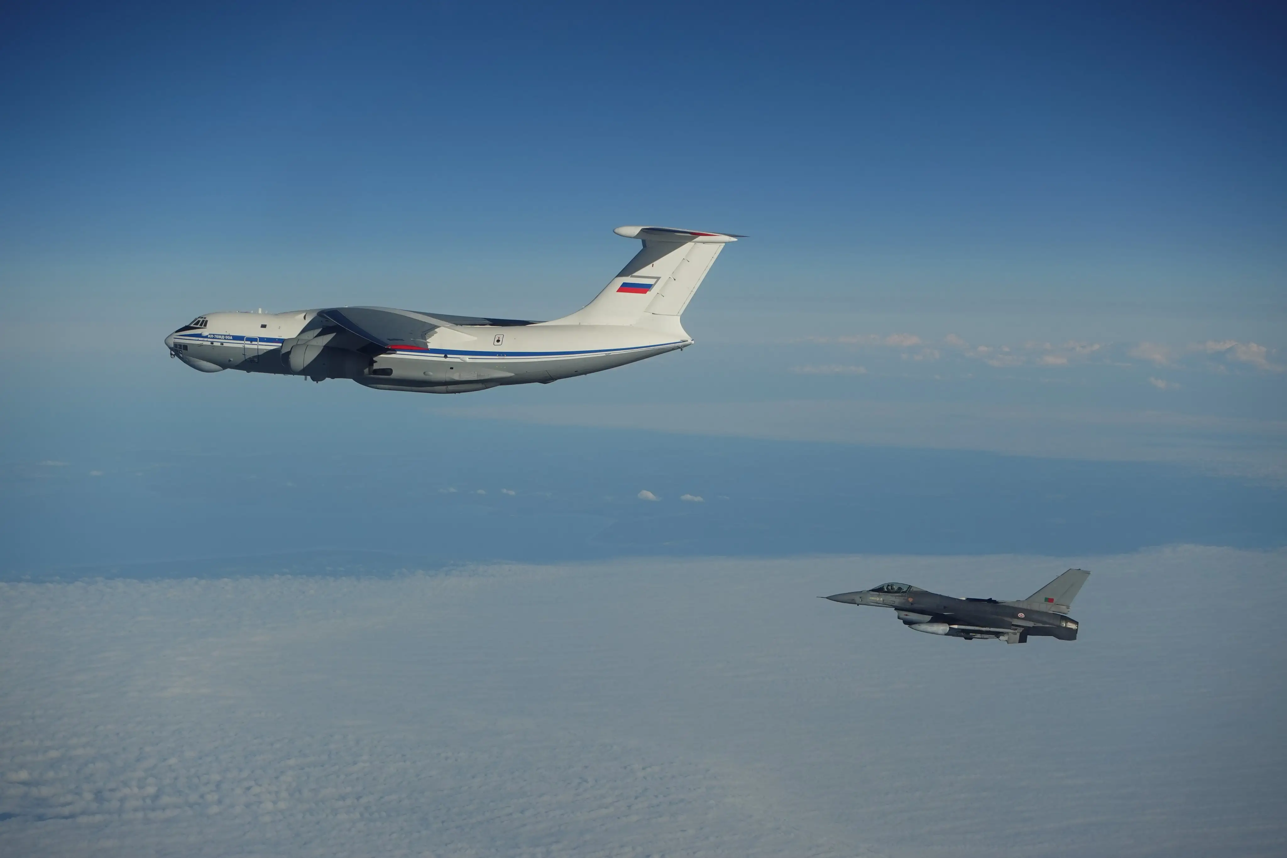 A NATO fighter jet flies near a Russian military plane.