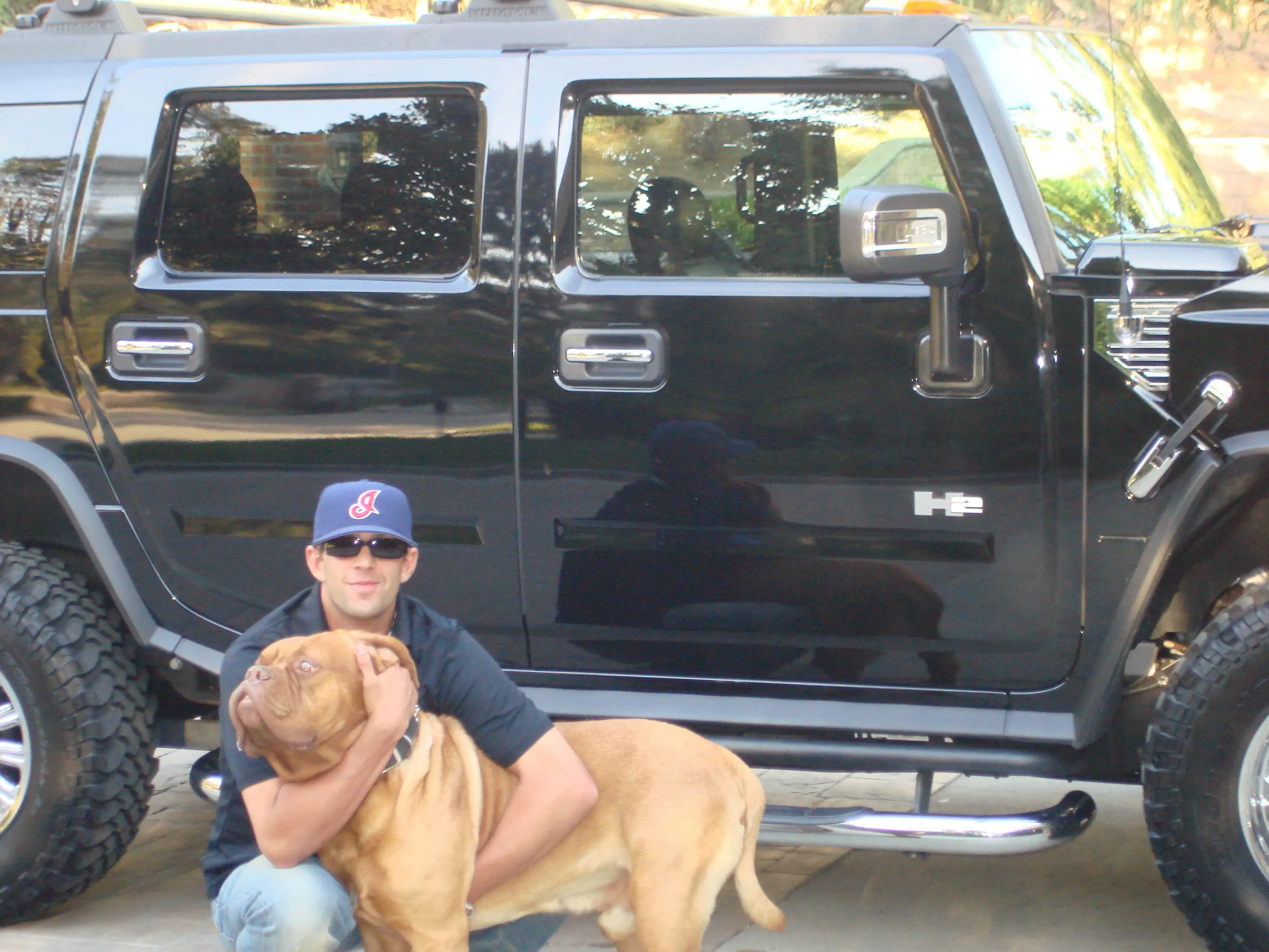 Costi Hinn in front of H2 hummer with dog.