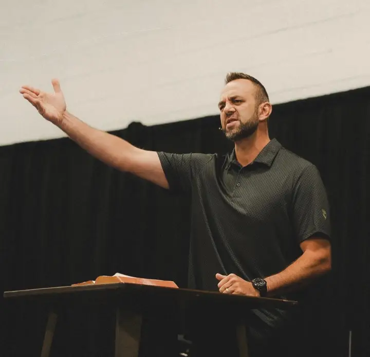 Costi Hinn in black polo shirt preaching.