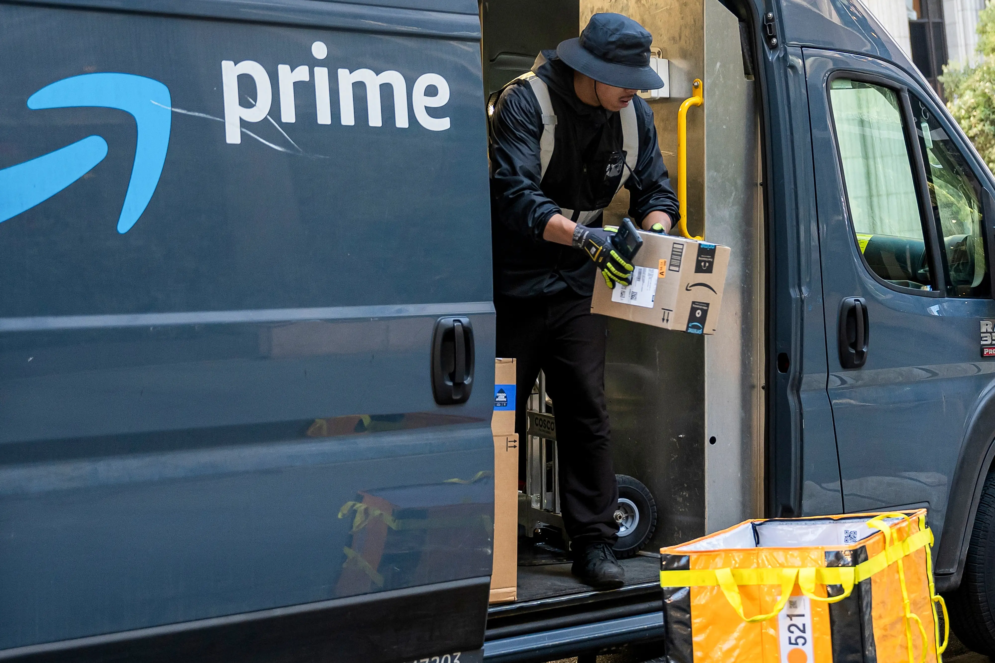 A worker unloads boxes from an Amazon delivery van in San Francisco, California