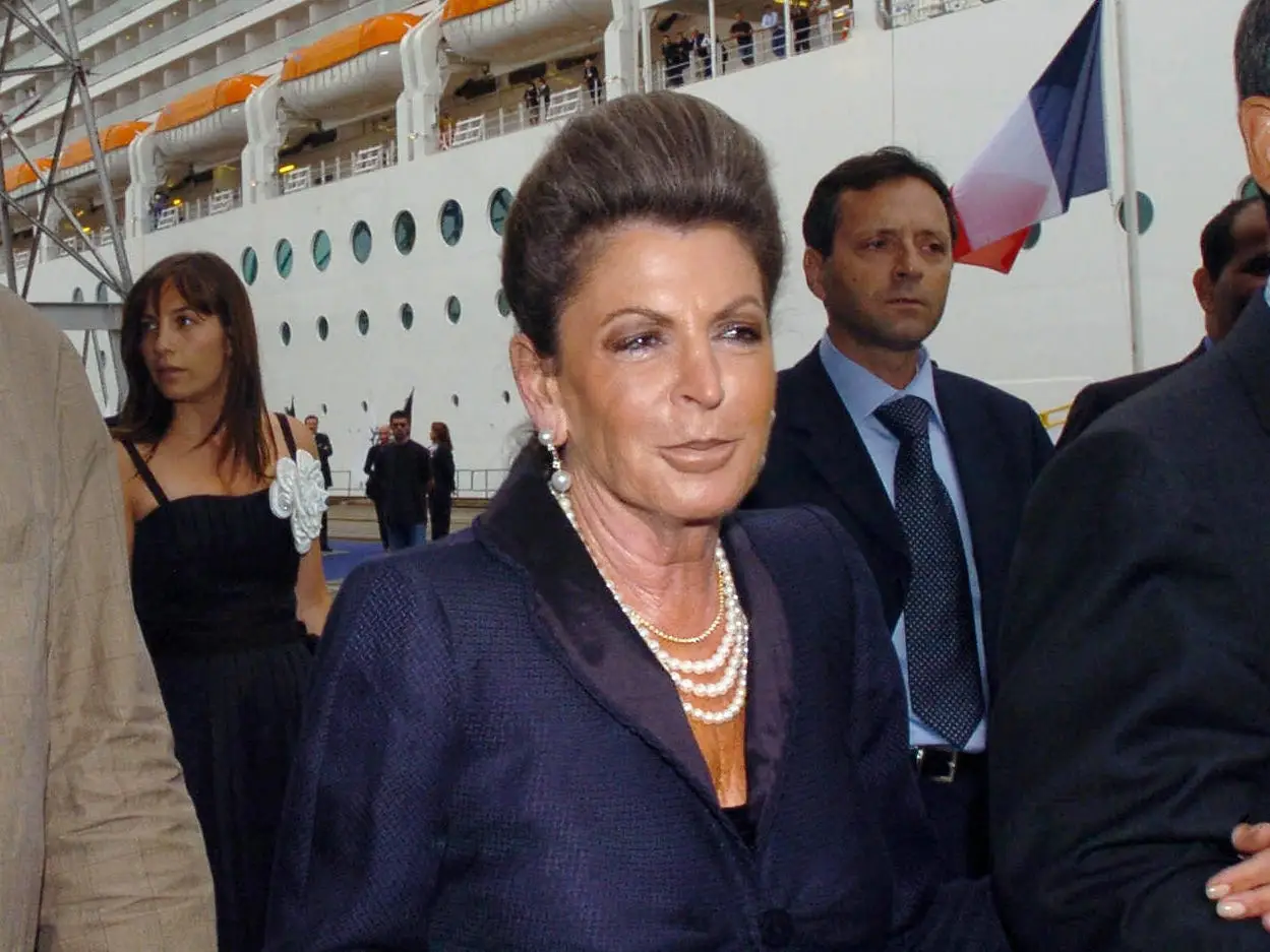 Rafaela Aponte-Diamant stands beside a large cruise ship during a dockside event.
