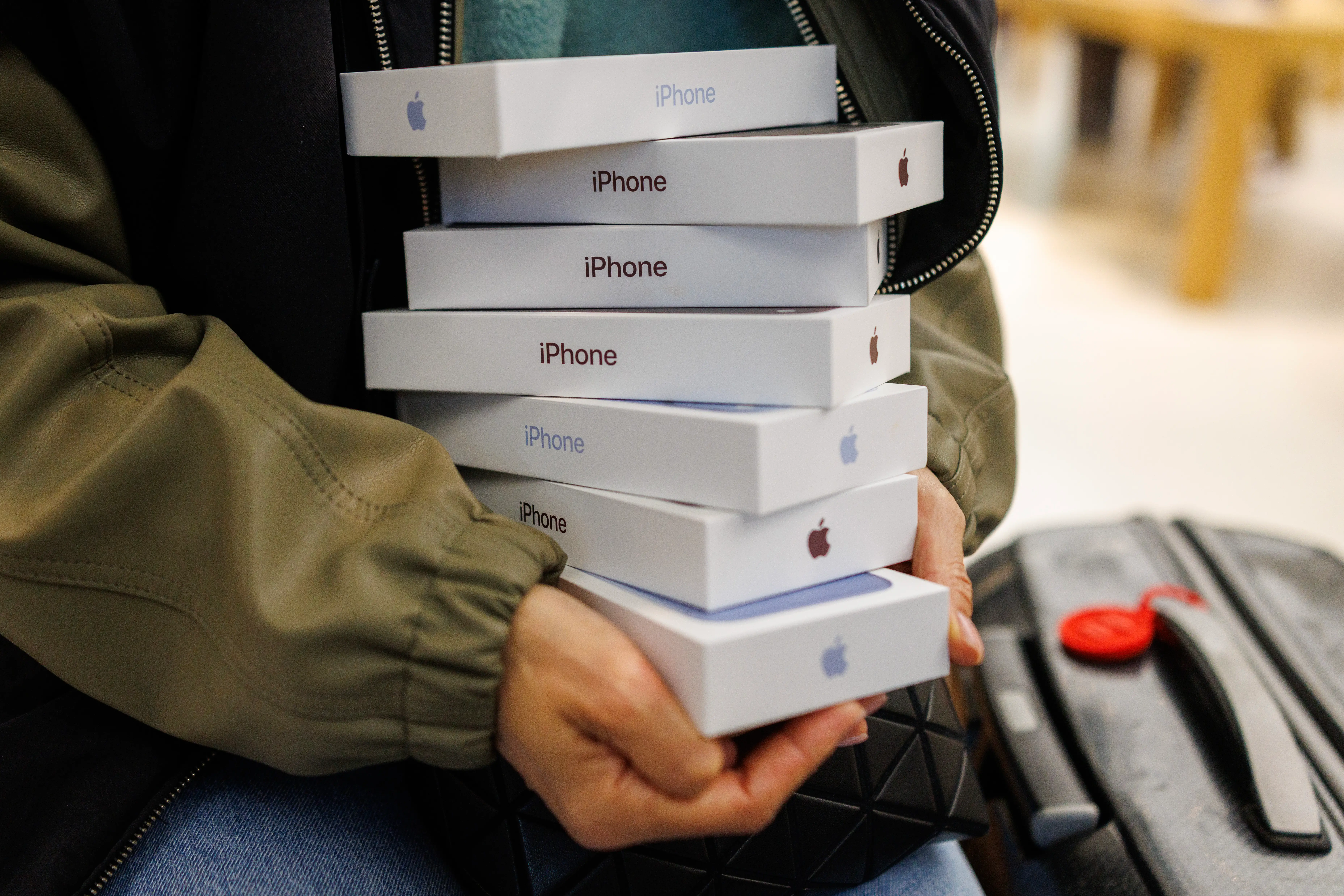A customer in London, England, holds seven iPhone 18 Pro boxes.