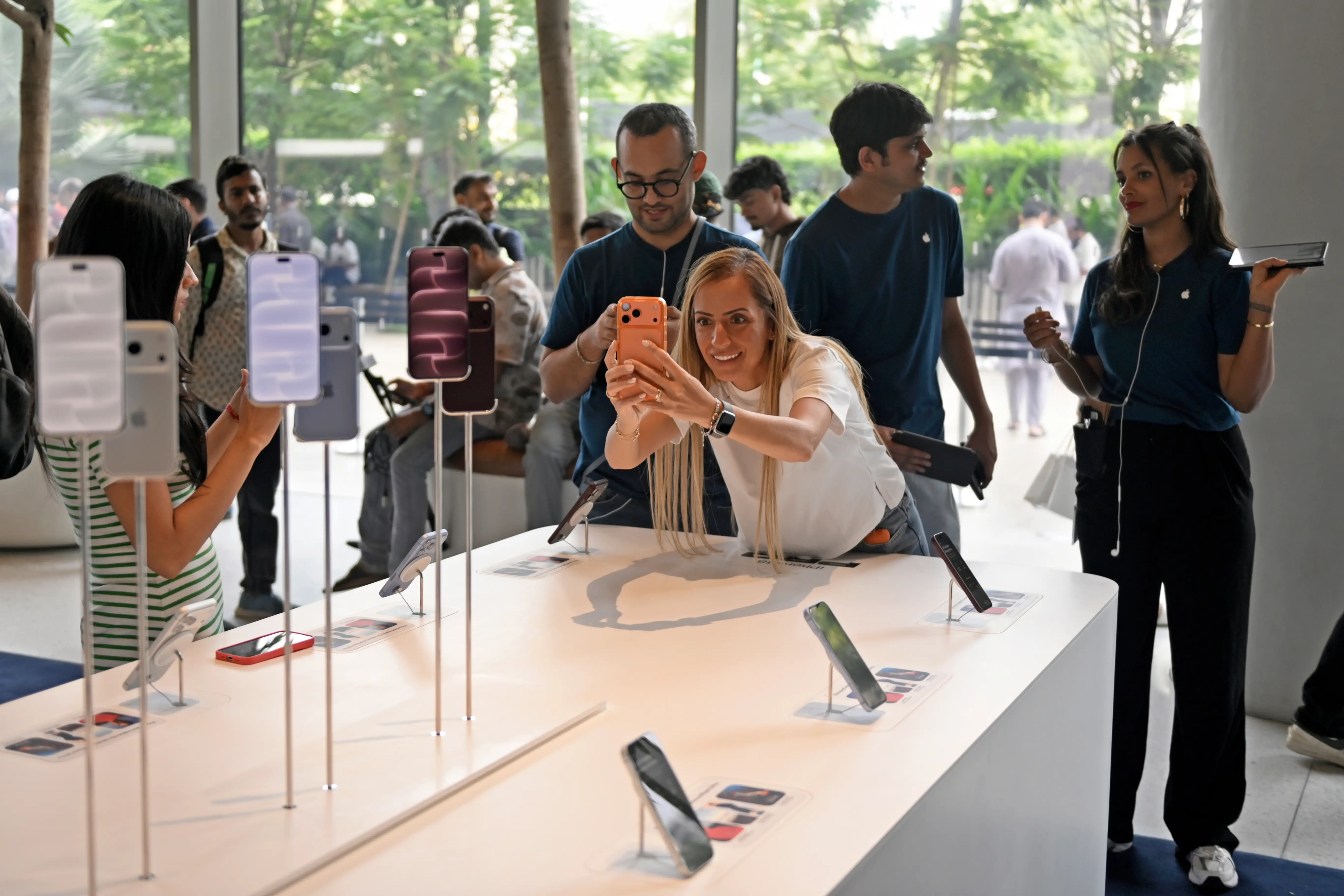 Shoppers in Mumbai, India, take pictures of the new iPhone 18 Pro display.