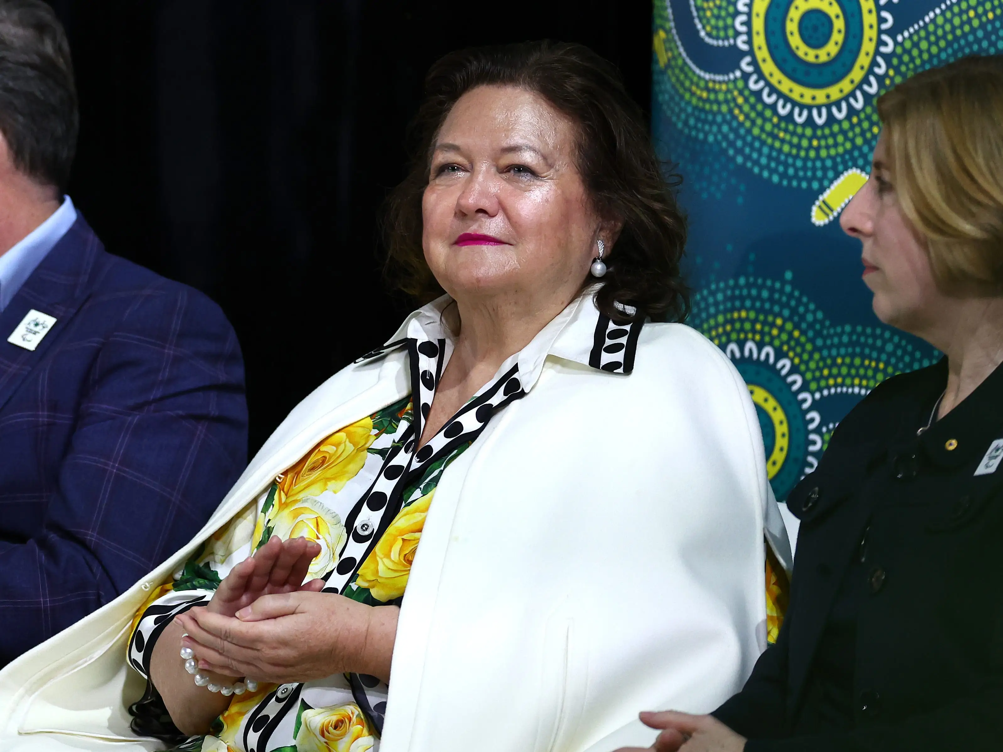 Gina Rinehart against a patterned backdrop and the central person draped in white.