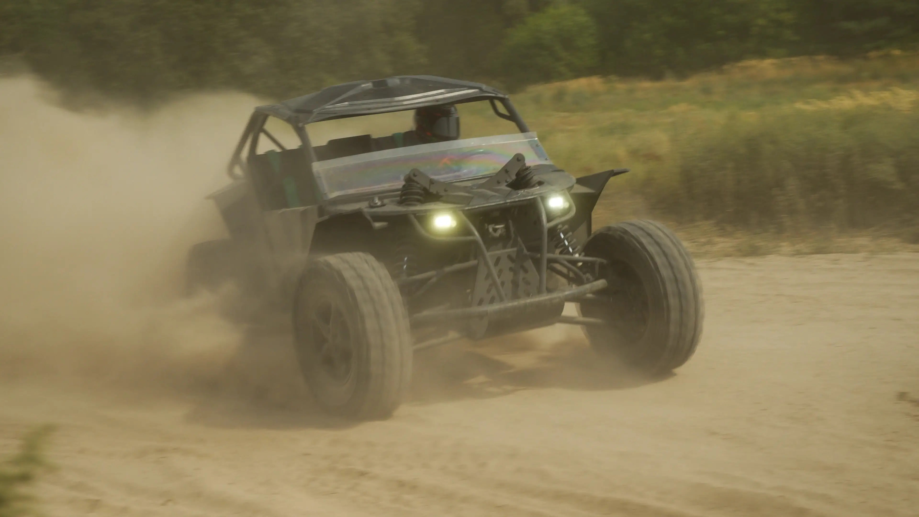 Off-road buggy with headlights drives through dust on a dirt track near trees and dry grass.