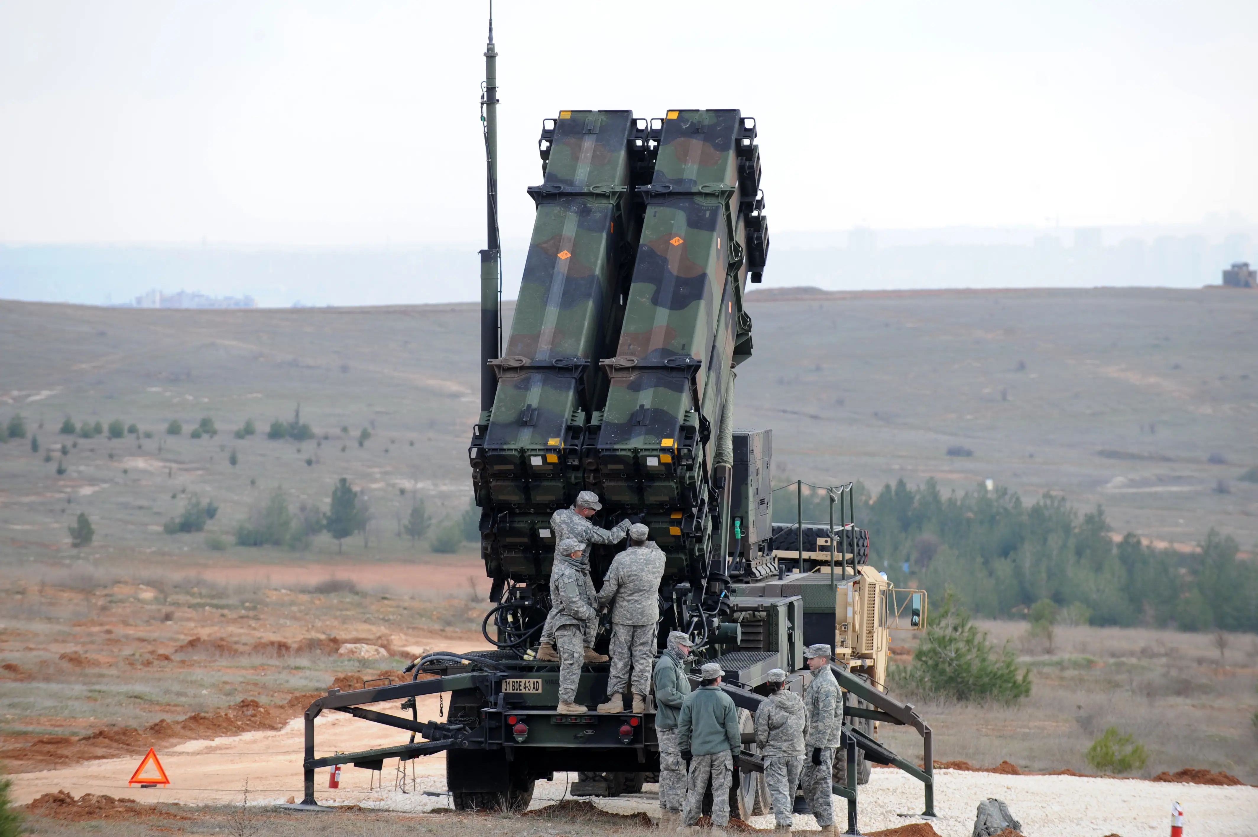 American soldiers go to work on the back of a Patriot missile system.