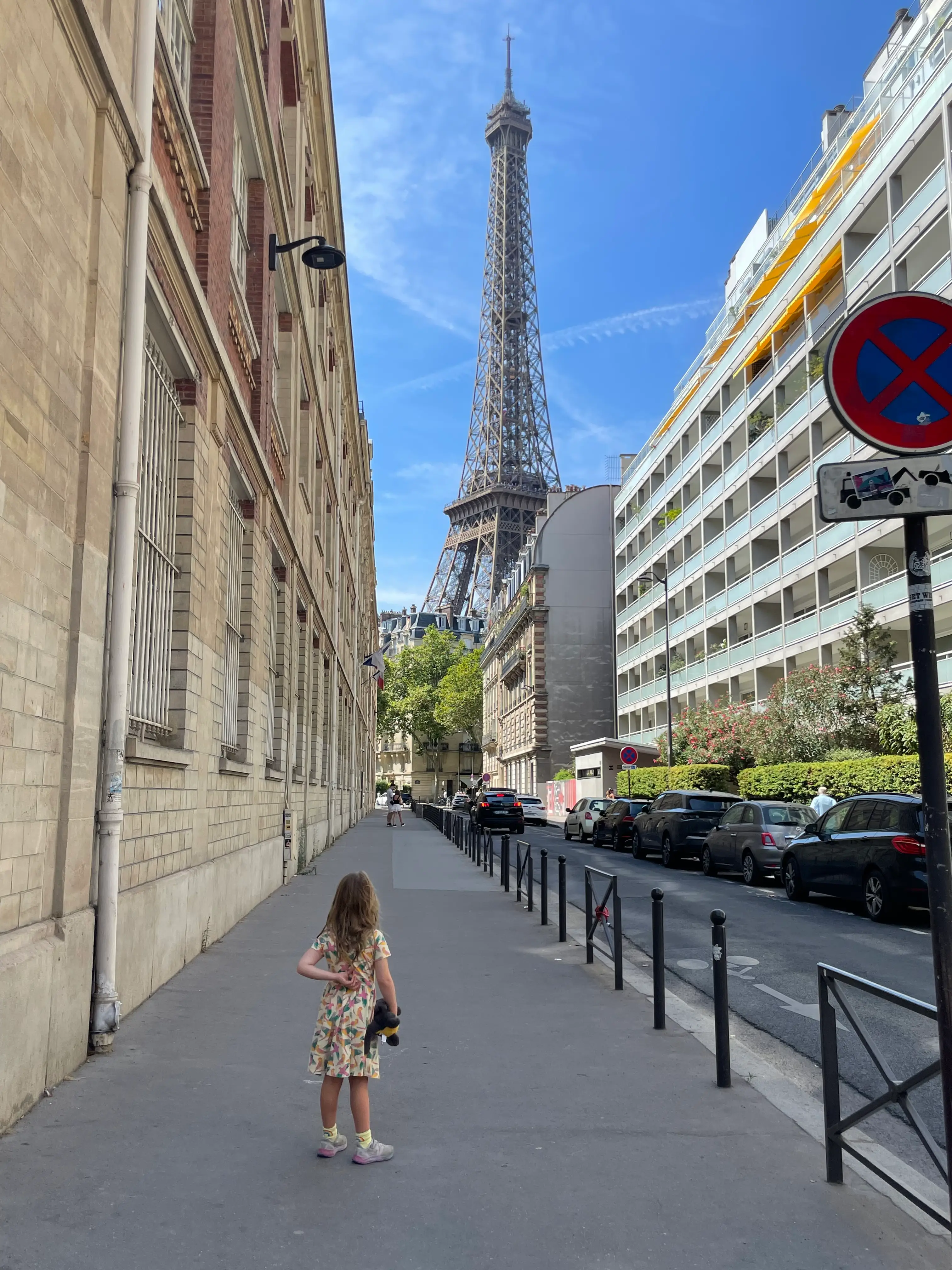The author's daughter is shown on a street in Paris looking at the Eiffel Tower.