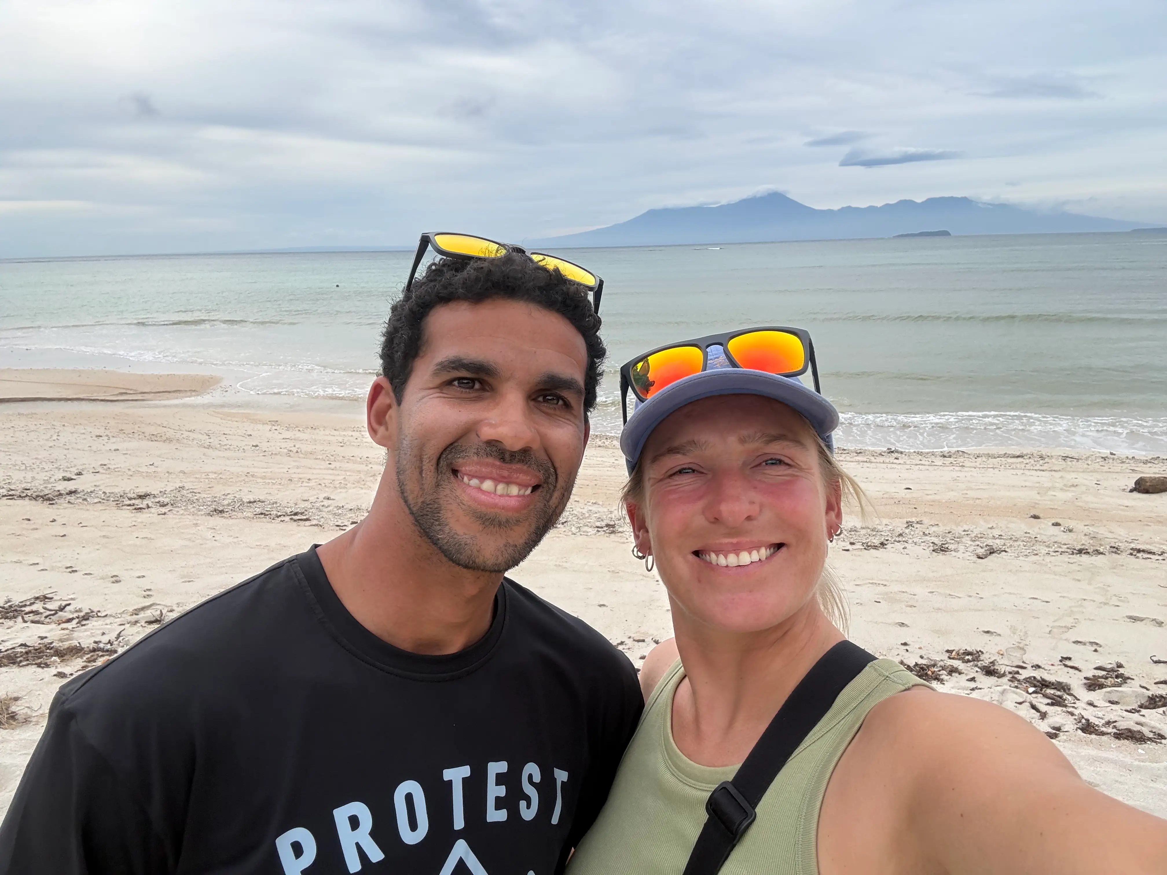 A couple with the beach in the background.