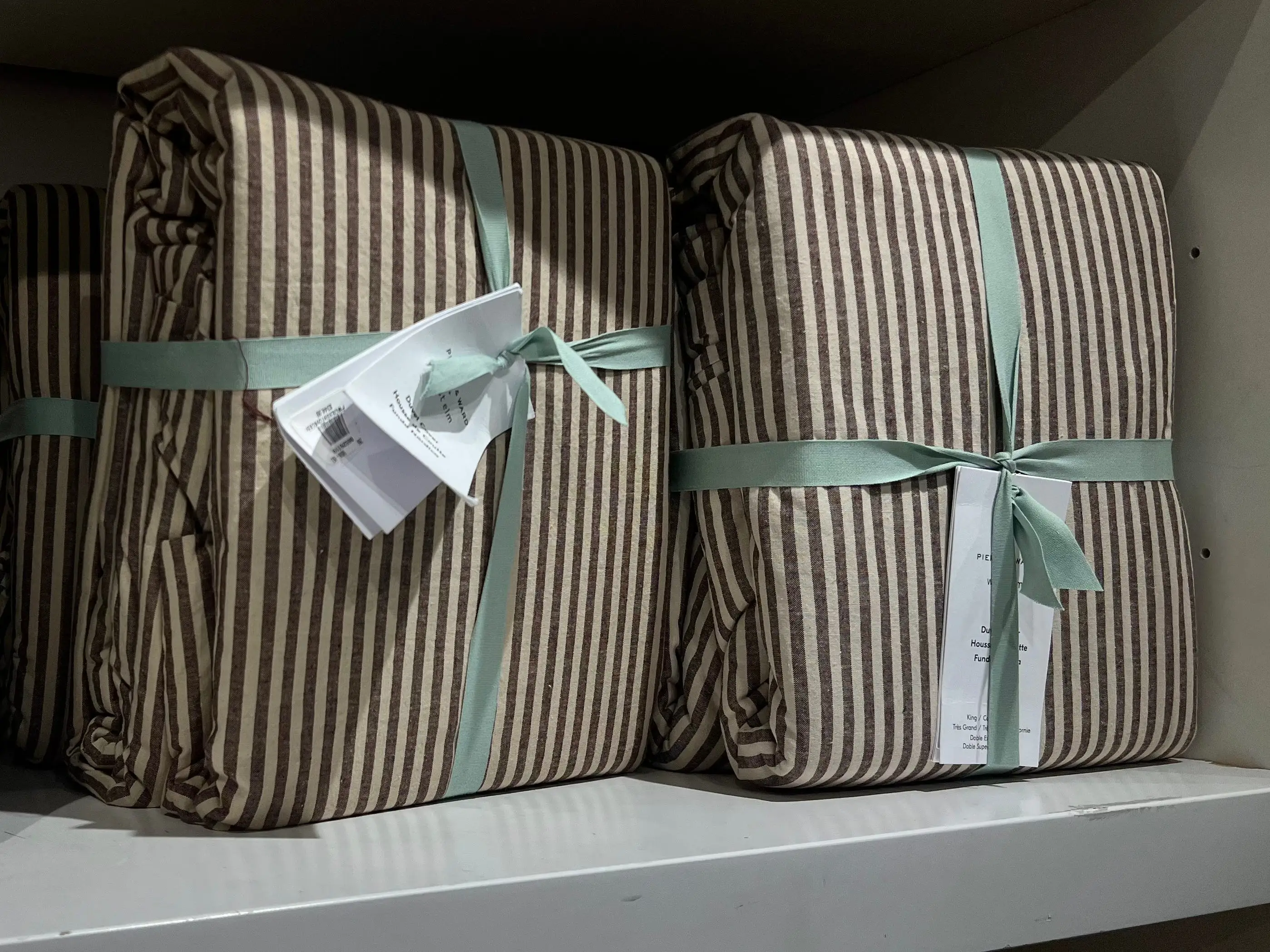 Two striped duvet covers on a shelf.