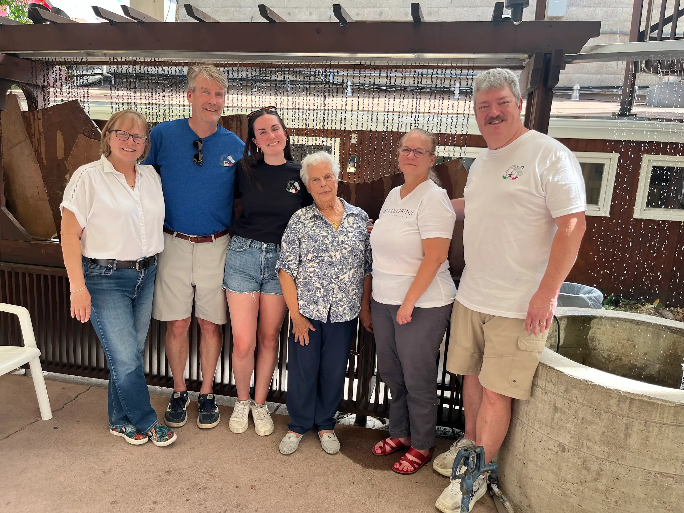 The writer stands in a line with five intergenerational friends, smiling at the camera.