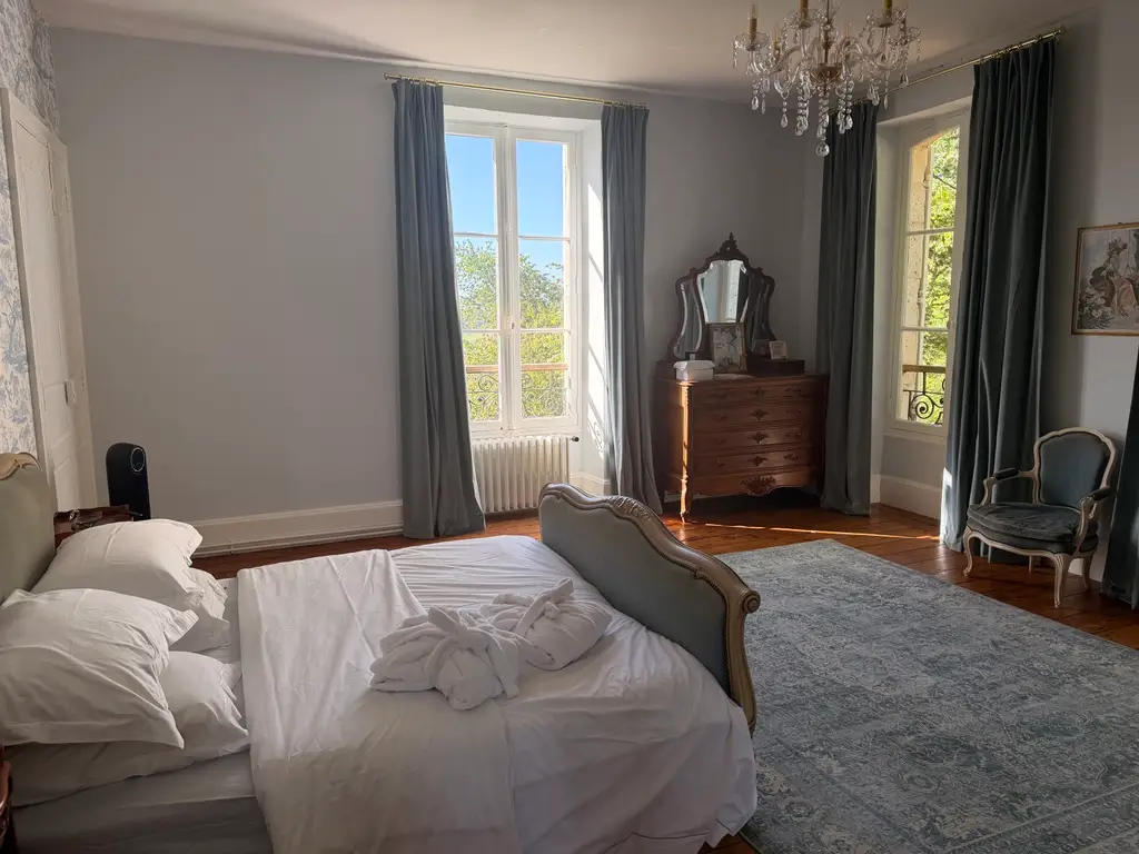 bedroom with large windows, wood dresser