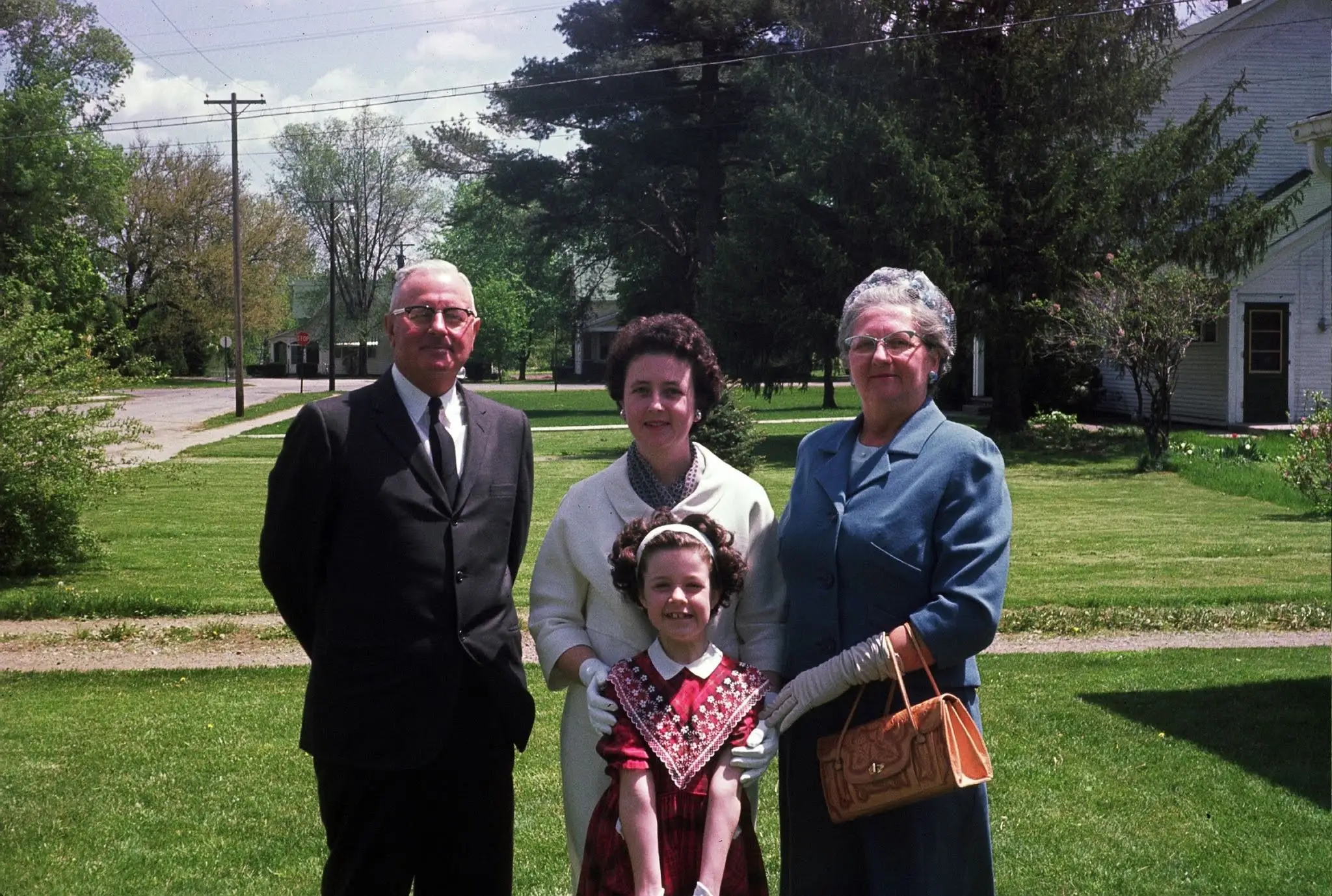 an old photograph of a family with a smiling young girl in the middle