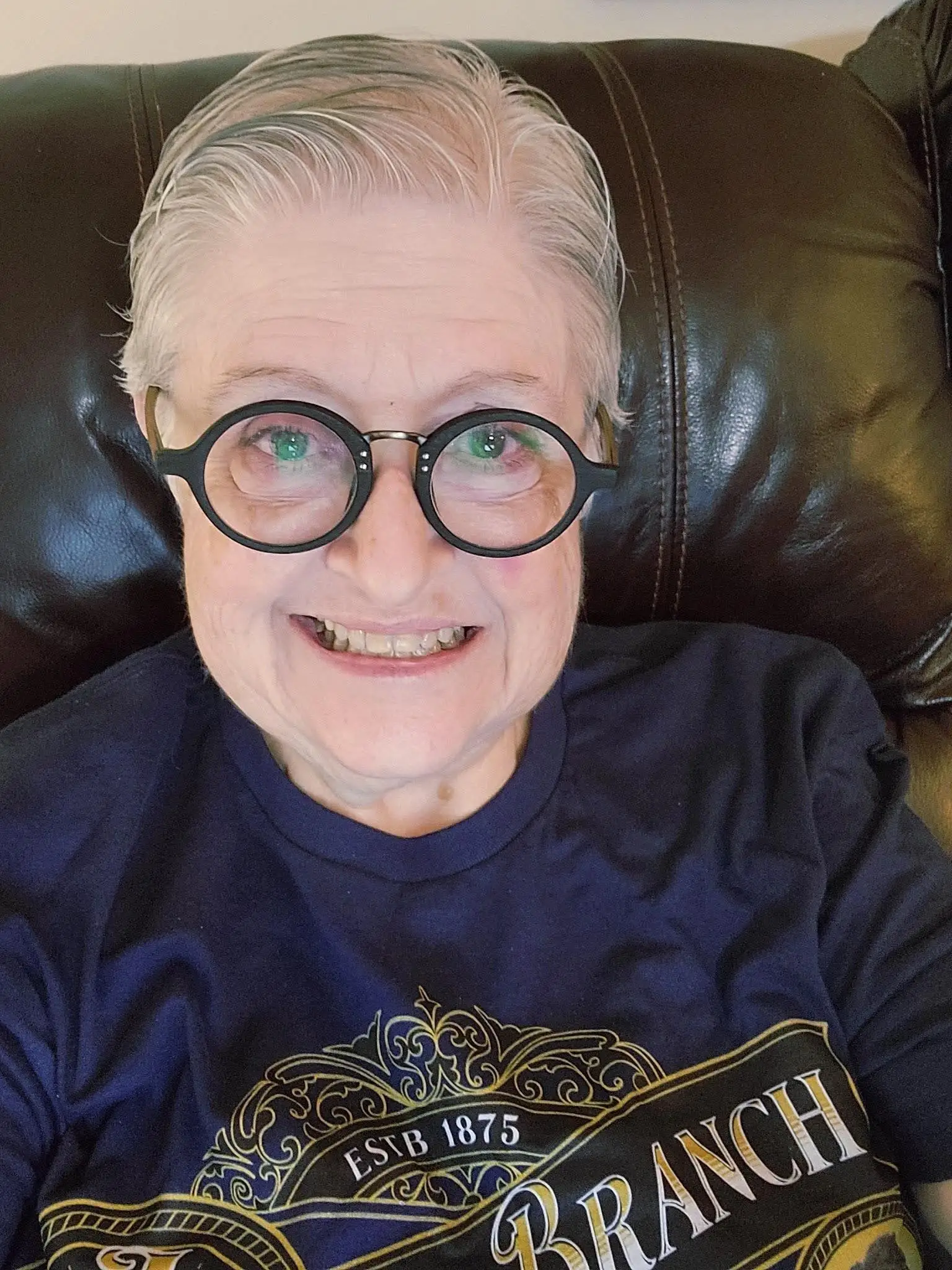 the author wearing black glasses and smiling